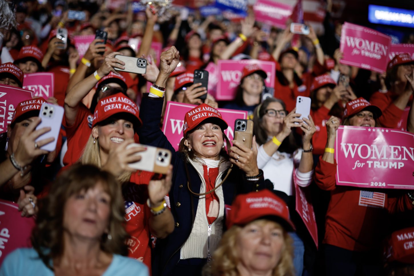 Supporters hold "Women for Trump" signs as they watch Republican presidential nominee former President Donald Trump speak at a campaign rally at the Santander Arena on November 04, 2024 in Reading, Pennsylvania