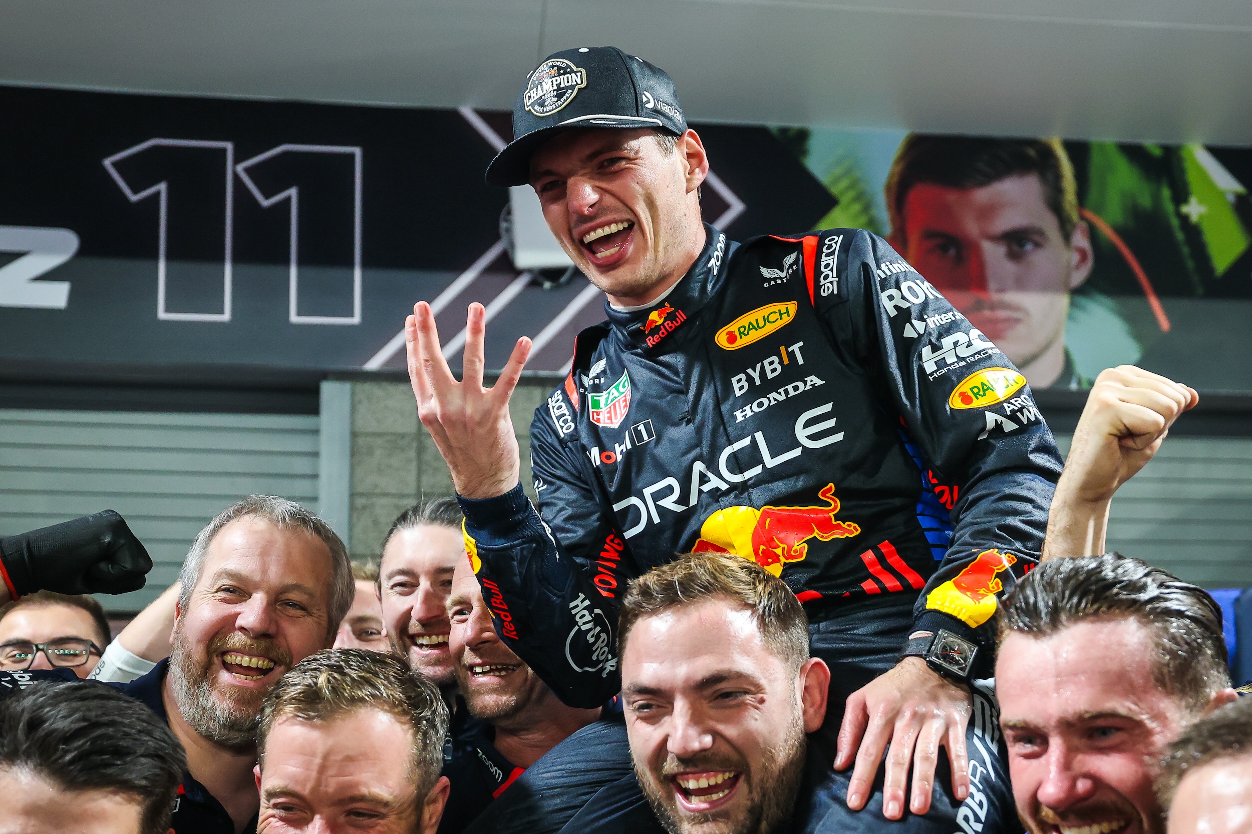 Max Verstappen celebrates his championship on the shoulders of teammates.