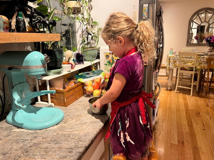 A child whisking egg yolks and sugar.