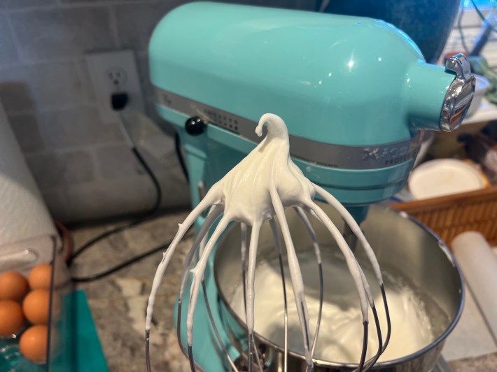 Whipped egg whites on a whisk.