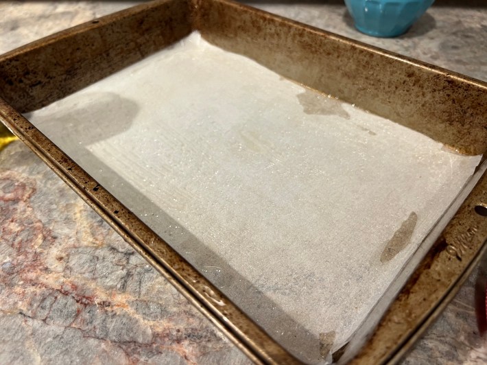 Oil and parchment paper in a rectangular baking pan.