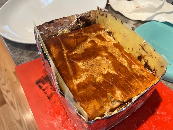 Jaconde sponge, brushed with coffee syrup, sits atop the stack inside a makeshift cake frame.