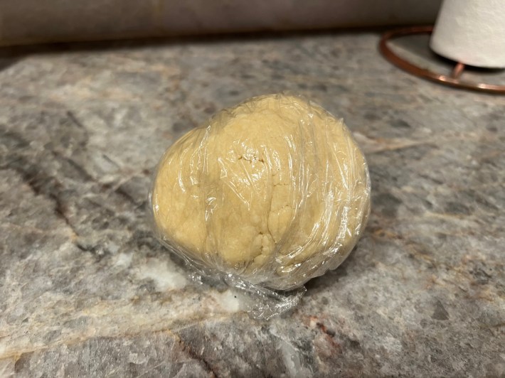 Dough clumped up inside a wrapping of plastic film.