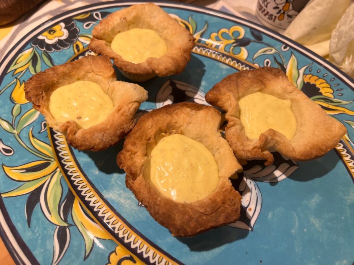 Four tart crusts filled with very wet crème pâtissière.