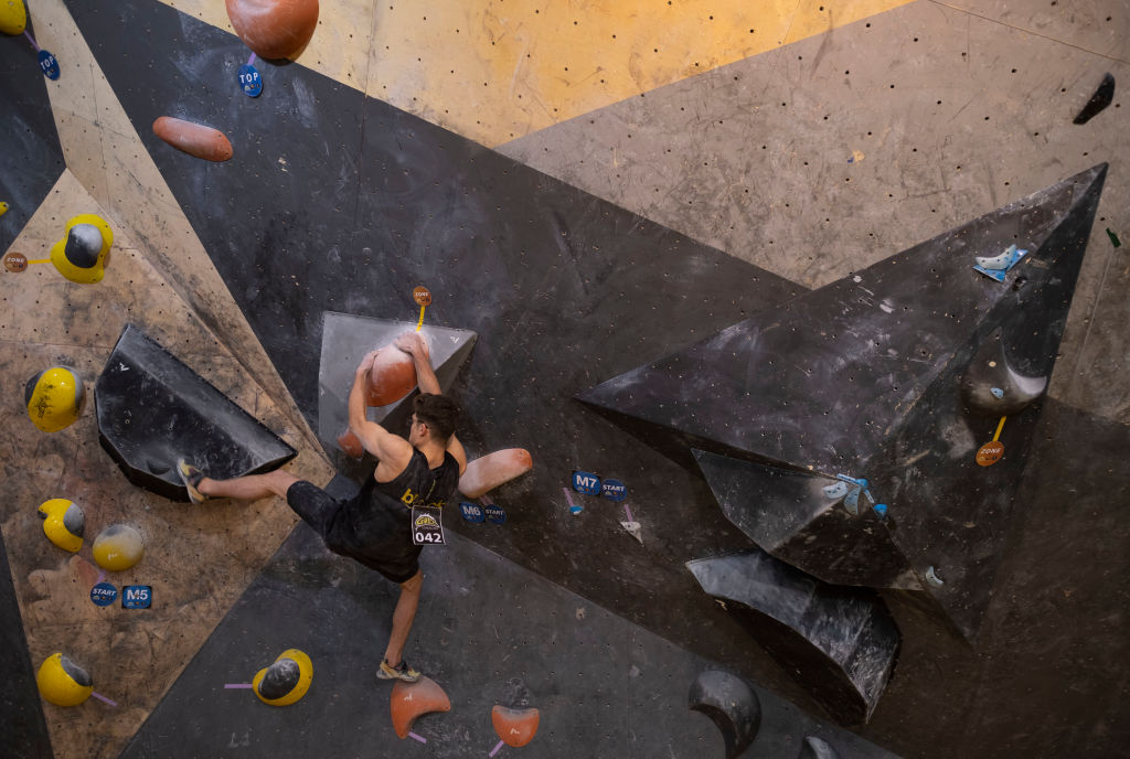 An Iranian rock climber scaling a climbing wall in Tehran.