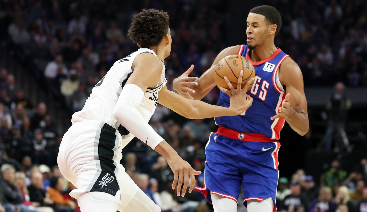 SACRAMENTO, CALIFORNIA - DECEMBER 01: Victor Wembanyama #1 of the San Antonio Spurs and Keegan Murray #13 of the Sacramento Kings go for a loose ball in the first half at Golden 1 Center on December 01, 2024 in Sacramento, California. (Photo by Ezra Shaw/Getty Images)