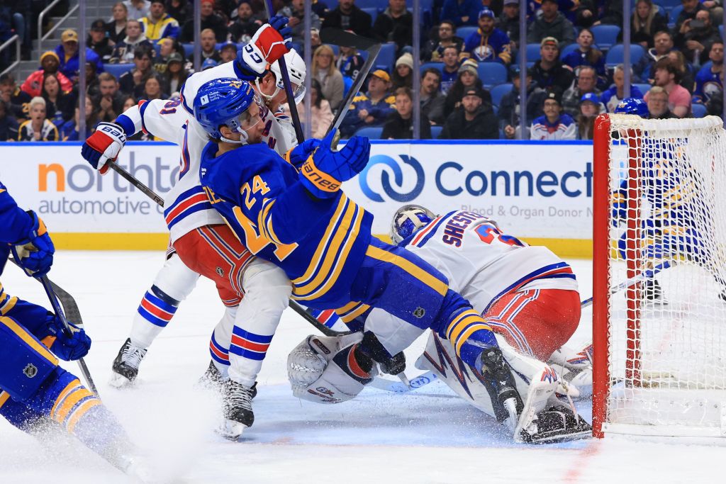 Dylan Cozens #24 of the Buffalo Sabres is driven toward the net