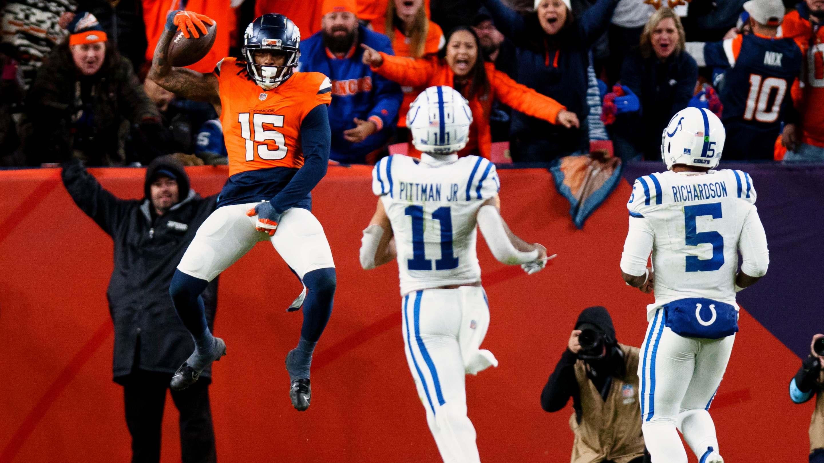 DENVER, CO - DECEMBER 15: Linebacker Nick Bonitto #15 of the Denver Broncos jumps backwards into the end zone for a pick six touchdown as wide receiver Michael Pittman Jr. #11 and quarterback Anthony Richardson #5 of the Indianapolis Colts look on during the fourth quarter at Empower Field at Mile High on December 15, 2024 in Denver, Colorado. (Photo by Justin Edmonds/Getty Images)