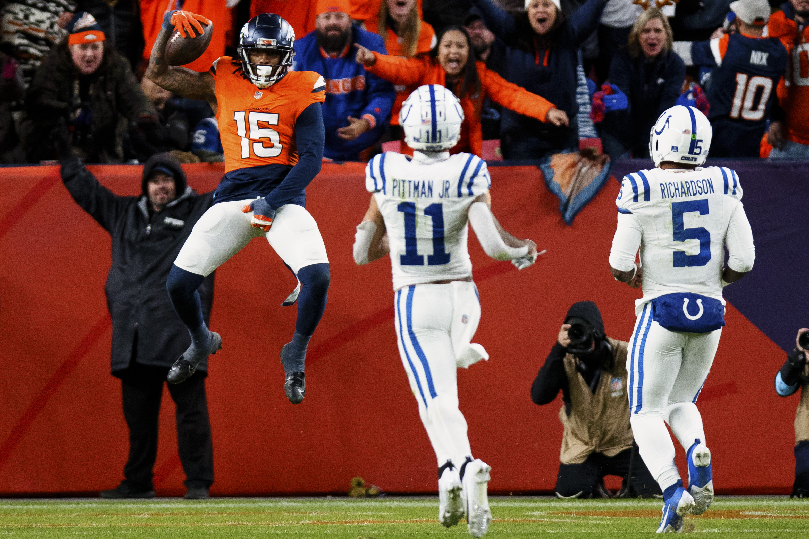 DENVER, CO - DECEMBER 15: Linebacker Nick Bonitto #15 of the Denver Broncos jumps backwards into the end zone for a pick six touchdown as wide receiver Michael Pittman Jr. #11 and quarterback Anthony Richardson #5 of the Indianapolis Colts look on during the fourth quarter at Empower Field at Mile High on December 15, 2024 in Denver, Colorado. (Photo by Justin Edmonds/Getty Images)