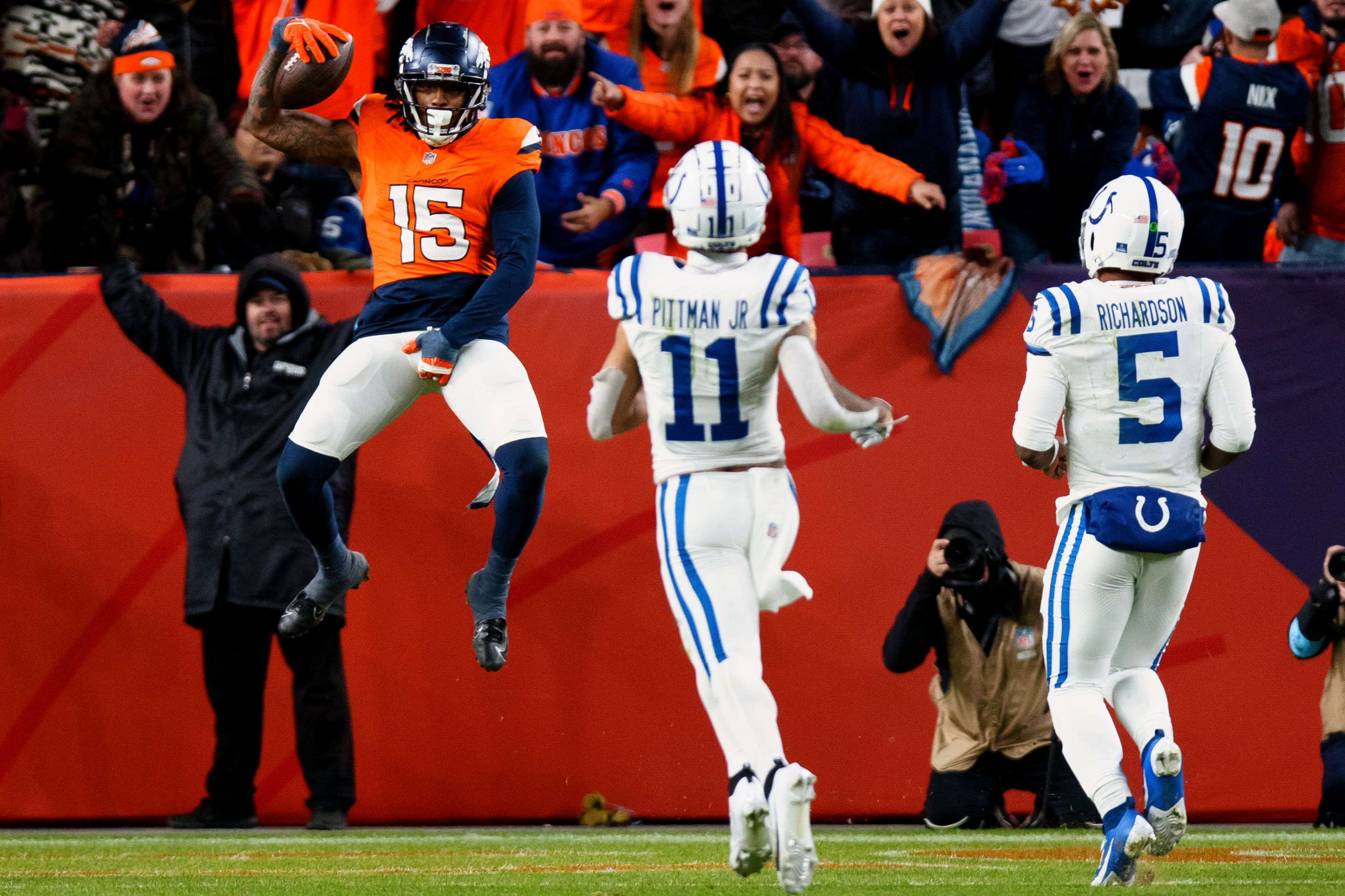 DENVER, CO - DECEMBER 15: Linebacker Nick Bonitto #15 of the Denver Broncos jumps backwards into the end zone for a pick six touchdown as wide receiver Michael Pittman Jr. #11 and quarterback Anthony Richardson #5 of the Indianapolis Colts look on during the fourth quarter at Empower Field at Mile High on December 15, 2024 in Denver, Colorado. (Photo by Justin Edmonds/Getty Images)