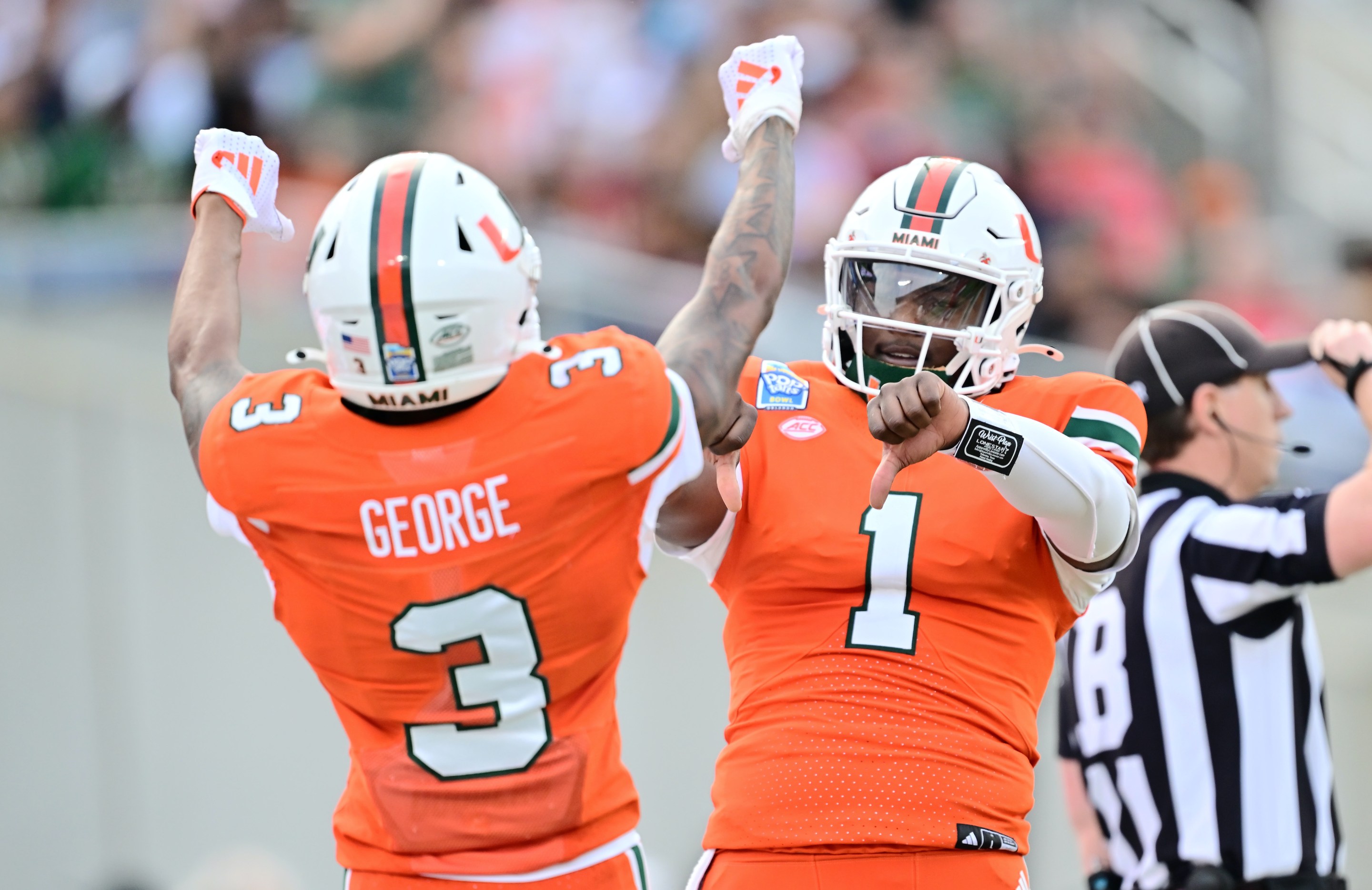 Cam Ward #1 of the Miami Hurricanes celebrates with Jacolby George #3 after connecting for a touchdown in the first quarter during the 2024 Pop-Tarts Bowl