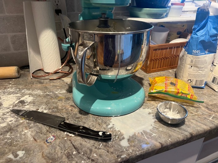 Flour, cornstarch, and warm milk befoul a kitchen countertop.