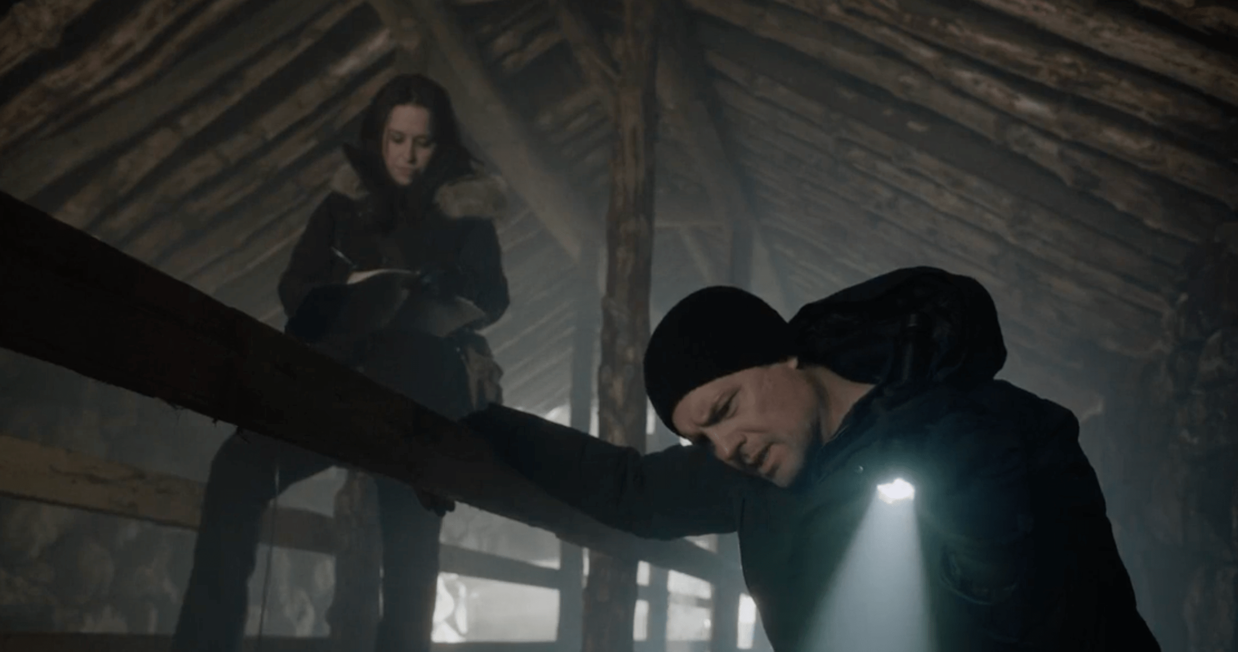 Lacey Chabert and her ex-husband in the movie The Christmas Quest, in an attic-like space shining a flashlight on something