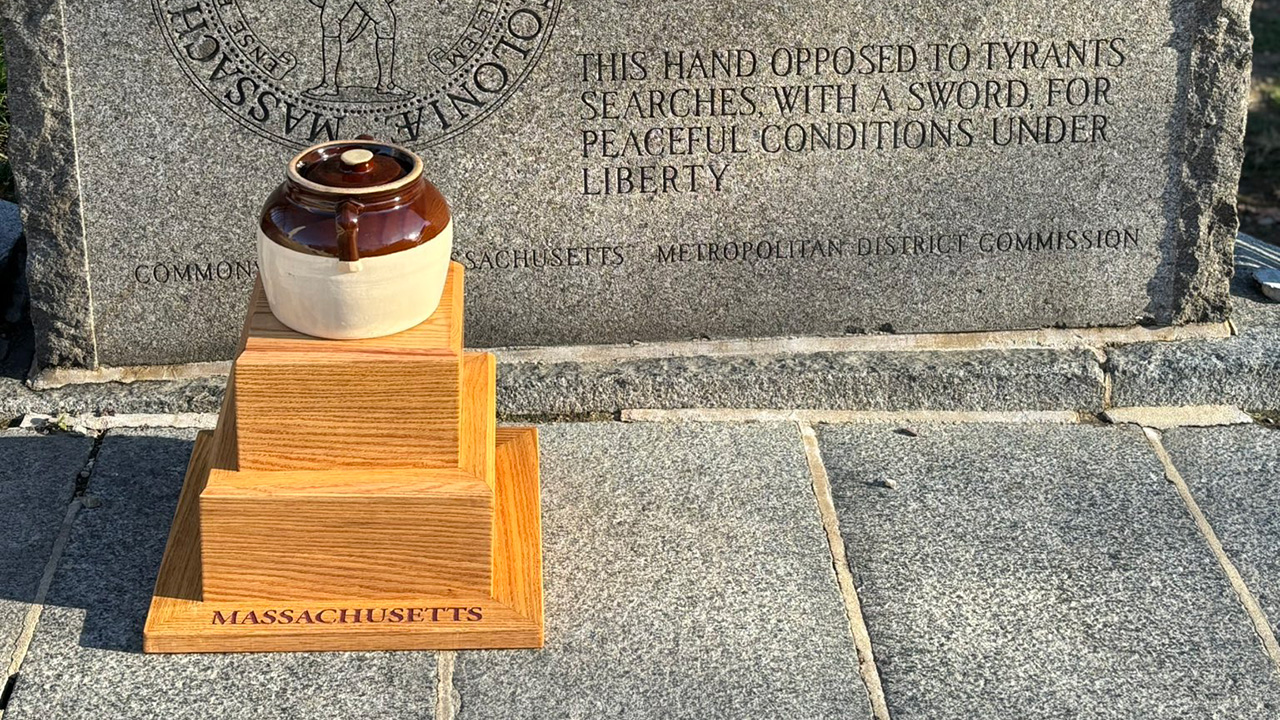 A beanpot on top of a small wooden base.