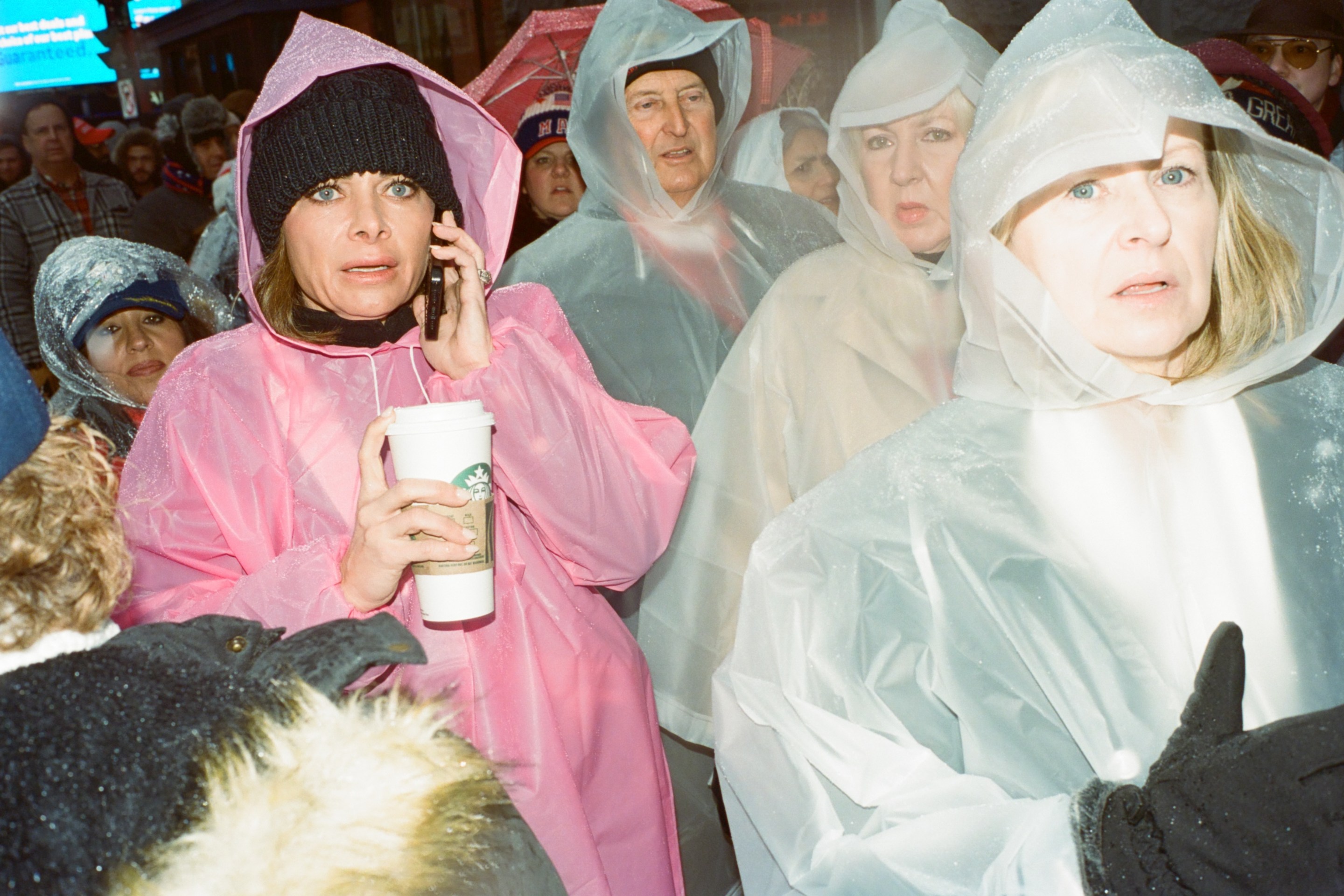 Trump fans in rain ponchos wait in the cold.