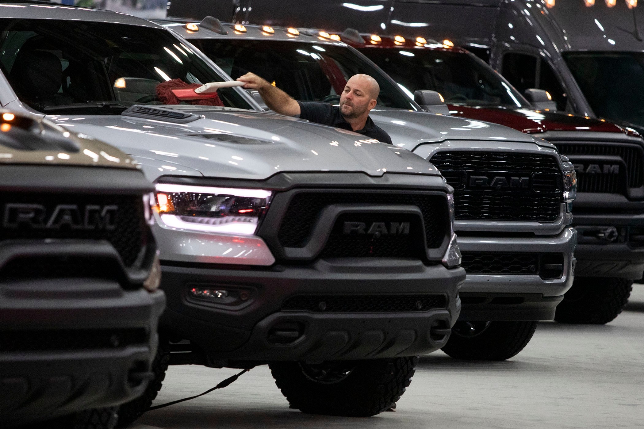 DETROIT, MI - SEPTEMBER 14: A worker cleans a RAM truck at the 2022 North American International Auto Show on September 14, 2022 in Detroit, Michigan.The NAIAS opens to the public on September 17 and features the latest state of the art electric vehicles, vehicle rides, the world’s first battery-powered Monster Truck, an Air Mobility Experience featuring flight demonstrations of jet suits, hoverboards, and vertical take-off and landing aircraft, a Dinosaur Encounter featuring 80 life-like and life-size dinosaurs, and the world’s largest rubber duck. (Photo by Bill Pugliano/Getty Images)