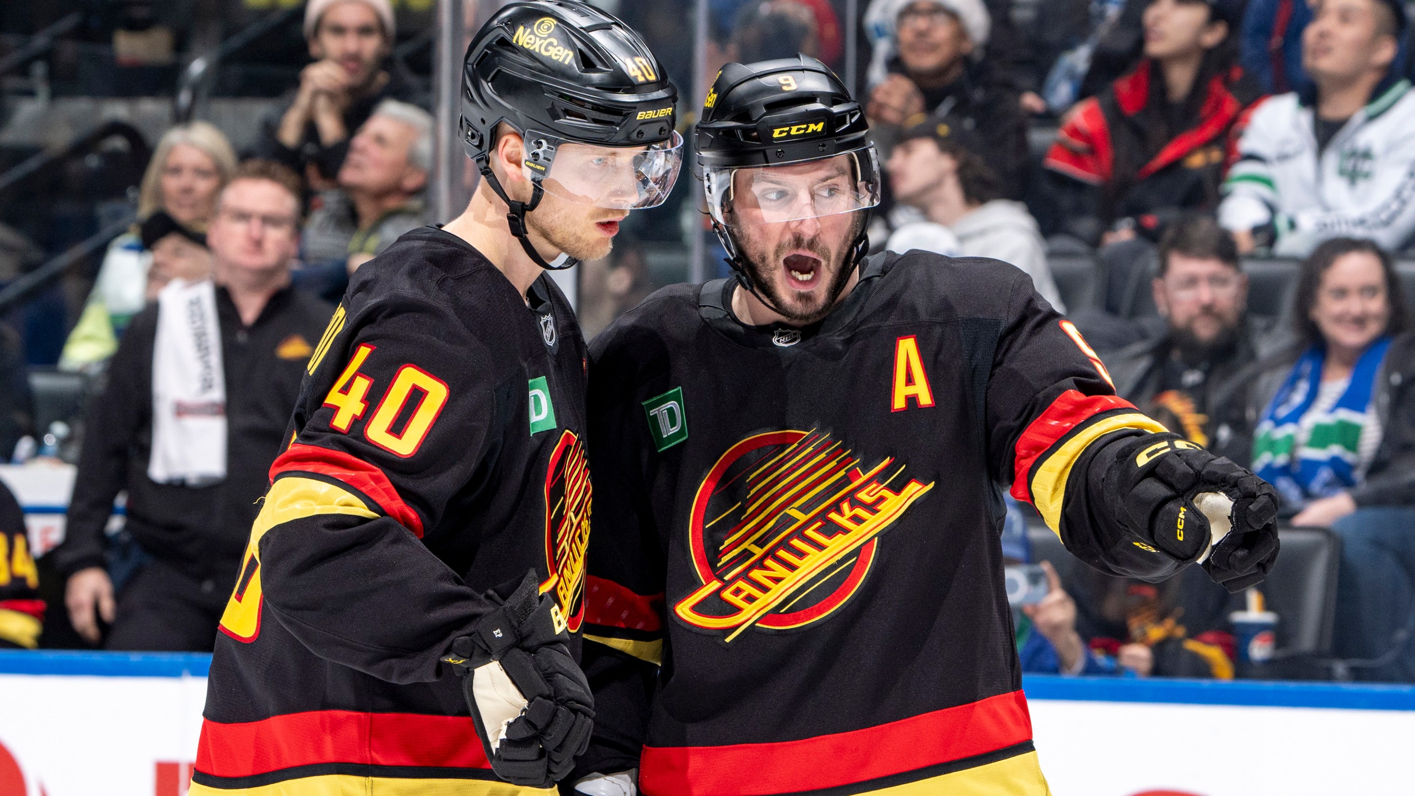 Elias Pettersson #40 and J.T. Miller #9 of the Vancouver Canucks discuss game play during the second period of their NHL game against the San Jose Sharks at Rogers Arena on December 23, 2024 in Vancouver, British Columbia, Canada.
