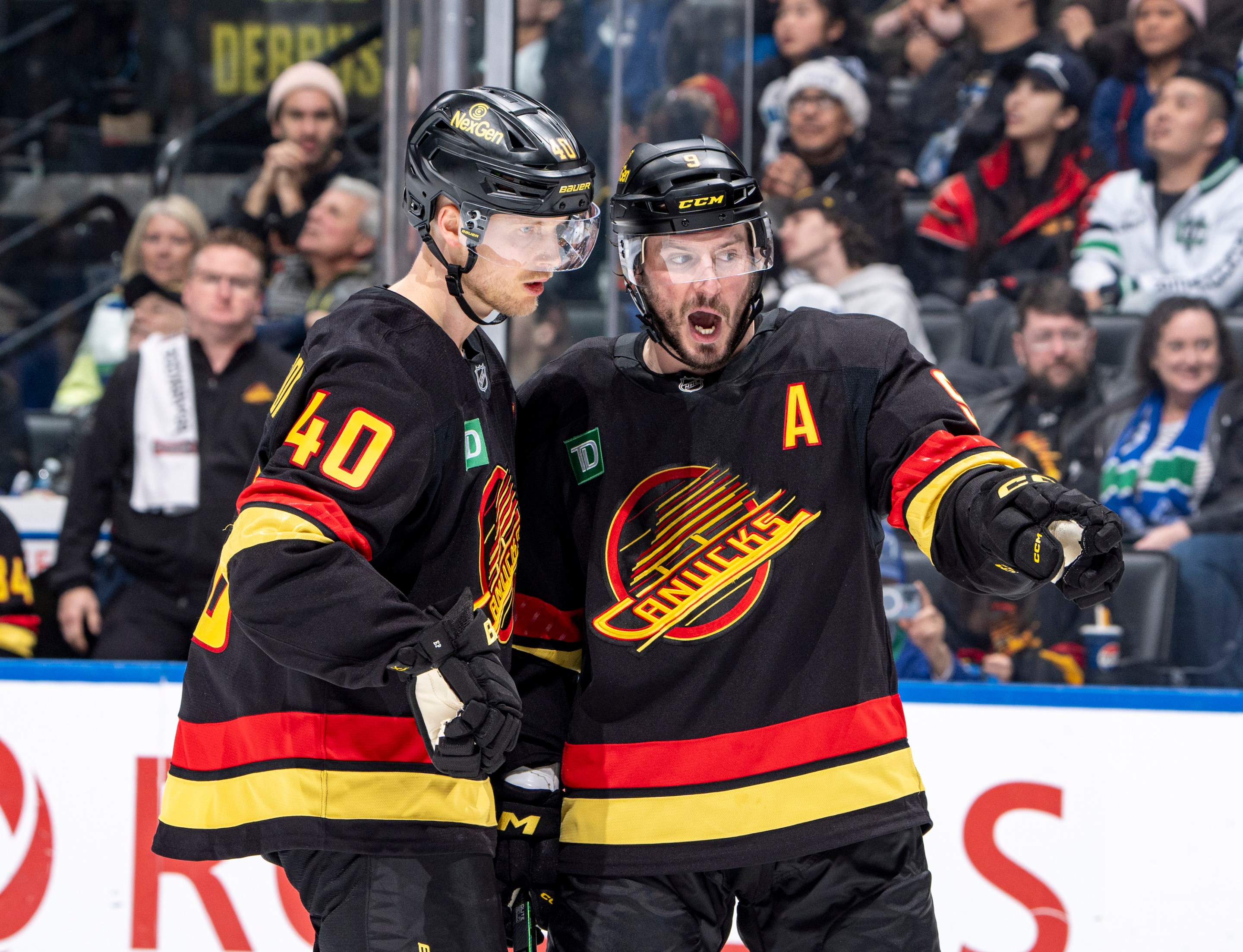 Elias Pettersson #40 and J.T. Miller #9 of the Vancouver Canucks discuss game play during the second period of their NHL game against the San Jose Sharks at Rogers Arena on December 23, 2024 in Vancouver, British Columbia, Canada.