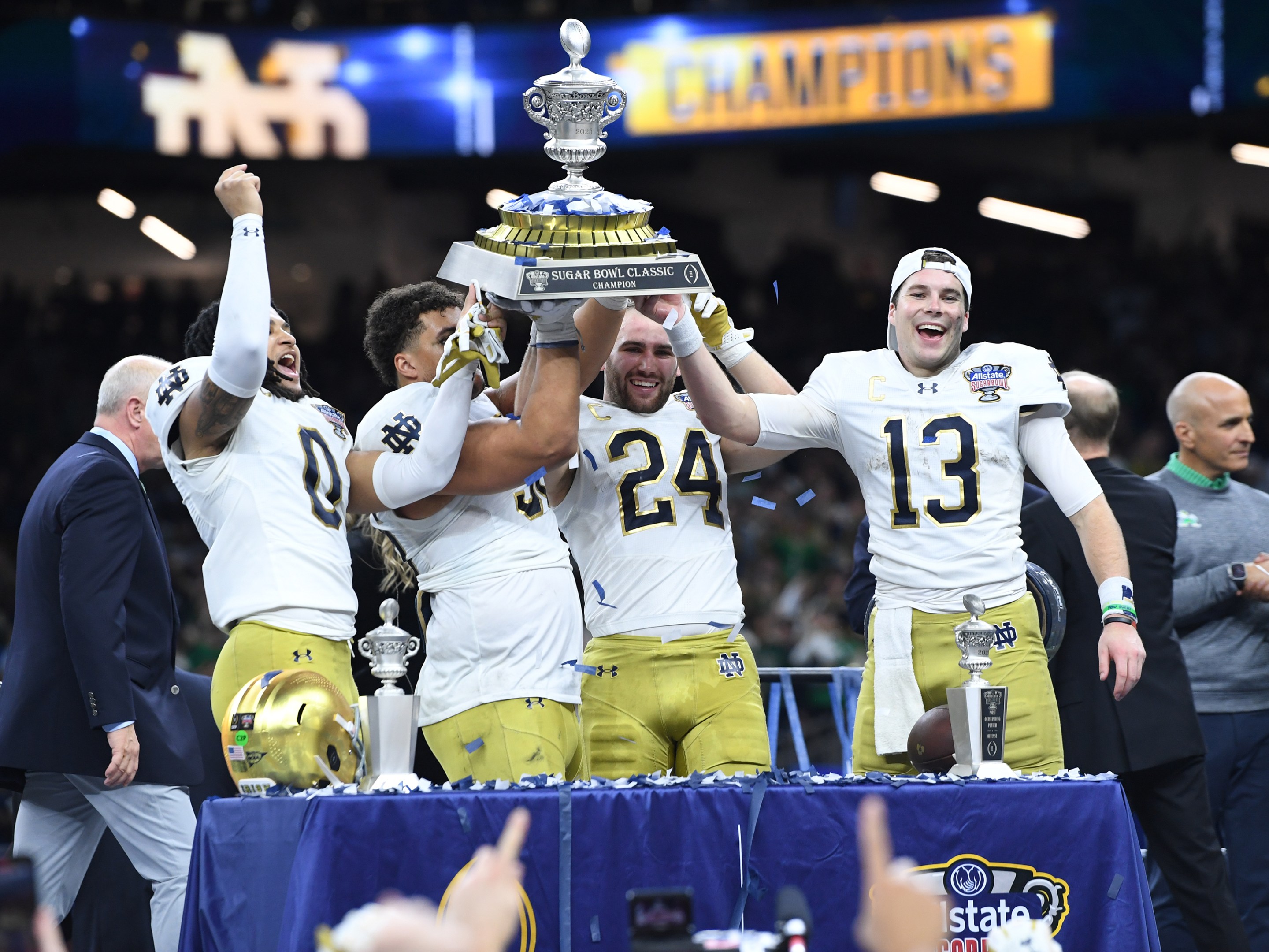 Safety Xavier Watts #0 of the Notre Dame Fighting Irish, Defensive Lineman Howard Cross III #56 of the Notre Dame Fighting Irish, Linebacker Jack Kiser #24 of the Notre Dame Fighting Irish and Quarterback Riley Leonard #13 of the Notre Dame Fighting Irish hoist the Allstate Sugar Bowl trophy after the Notre Dame Fighting Irish versus Georgia Bulldogs College Football Playoff Quarterfinal at the Allstate Sugar Bowl on January 2, 2025.