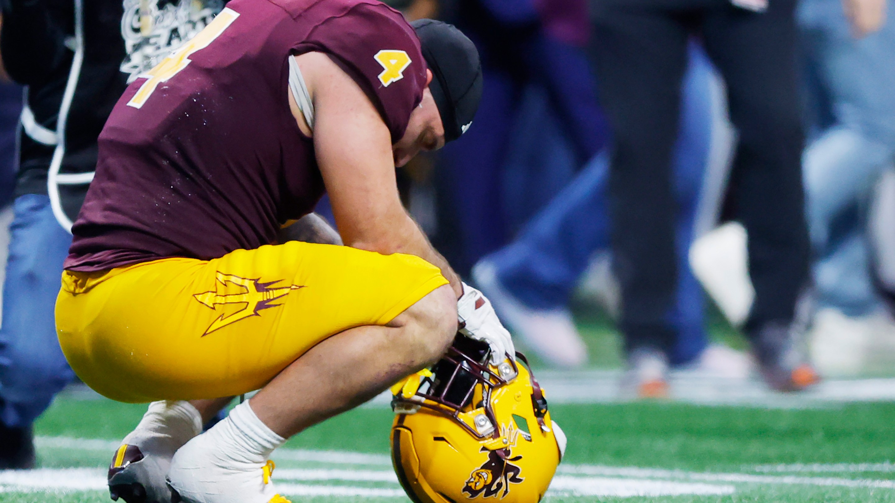 Cam Skattebo crouches on the field