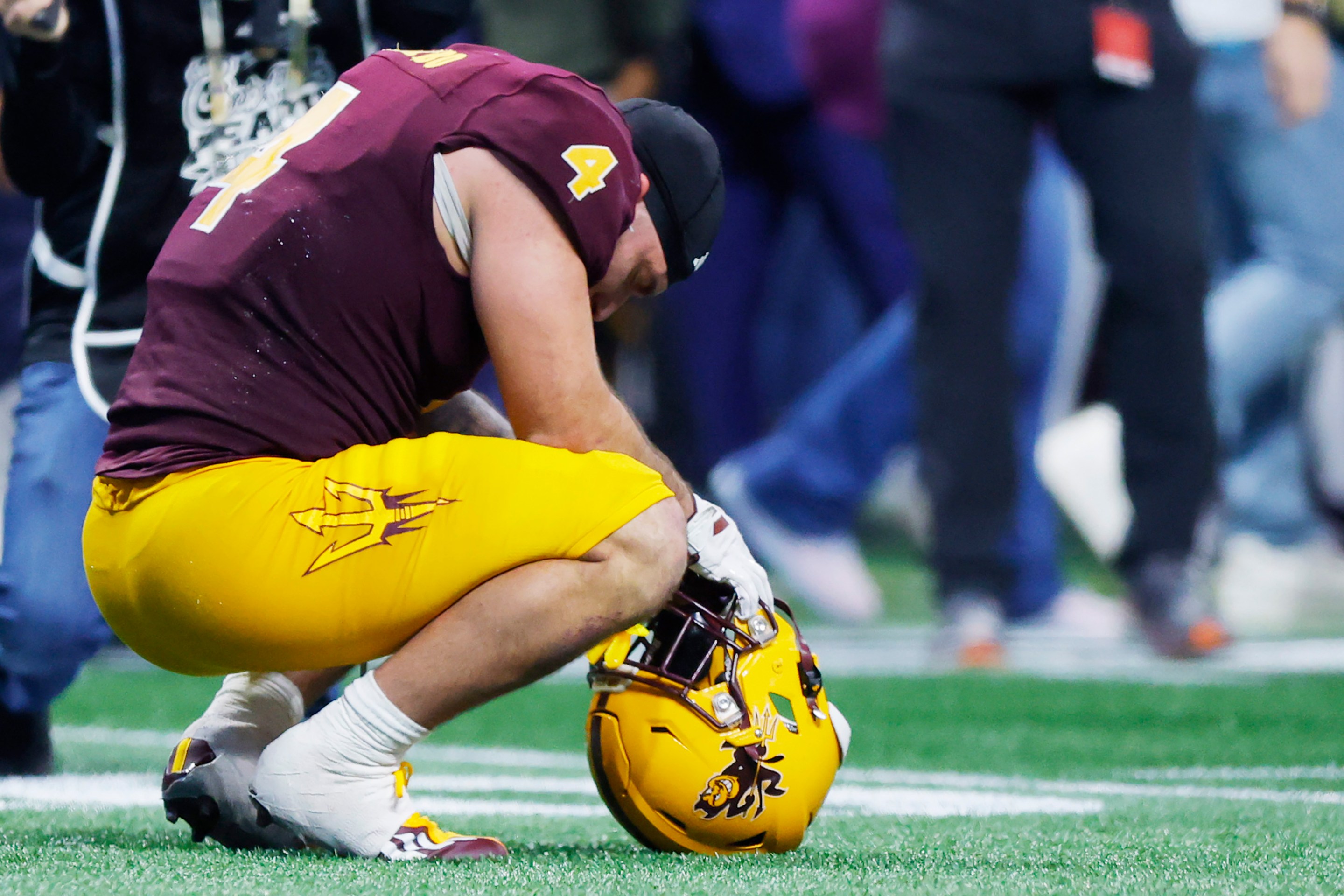 Cam Skattebo crouches on the field