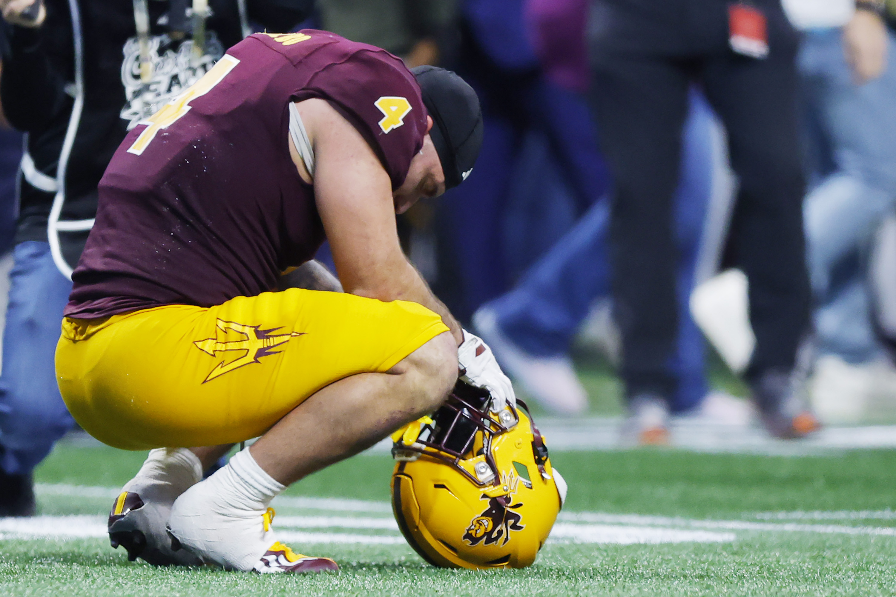 Cam Skattebo crouches on the field