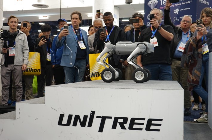 A bunch of people taking photos of a robot dog at CES in Las Vegas.