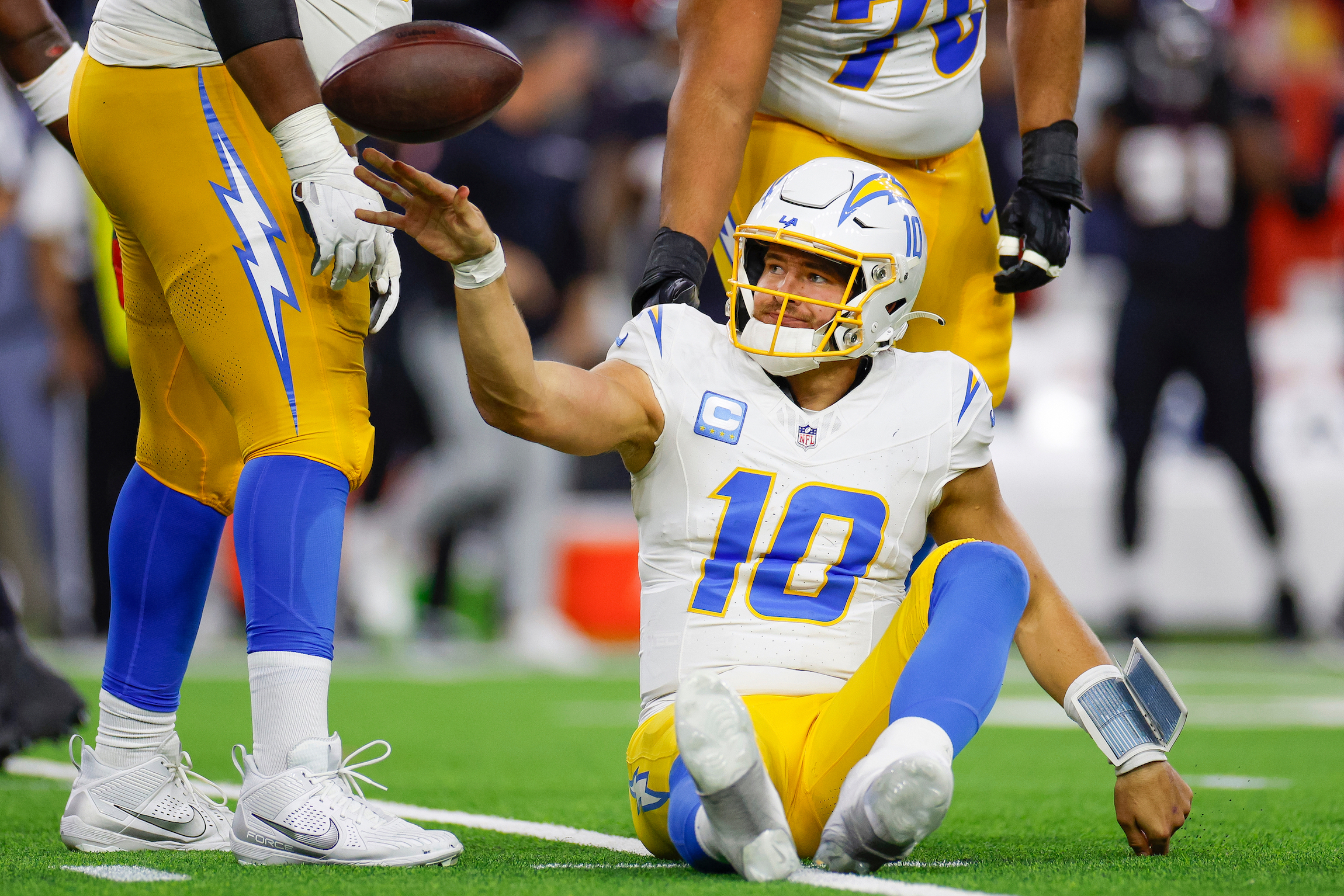 Justin Herbert #10 of the Los Angeles Chargers reacts after being sacked in the second half during the AFC Wild Card Playoff game against the Houston Texans at NRG Stadium on January 11, 2025 in Houston, Texas.