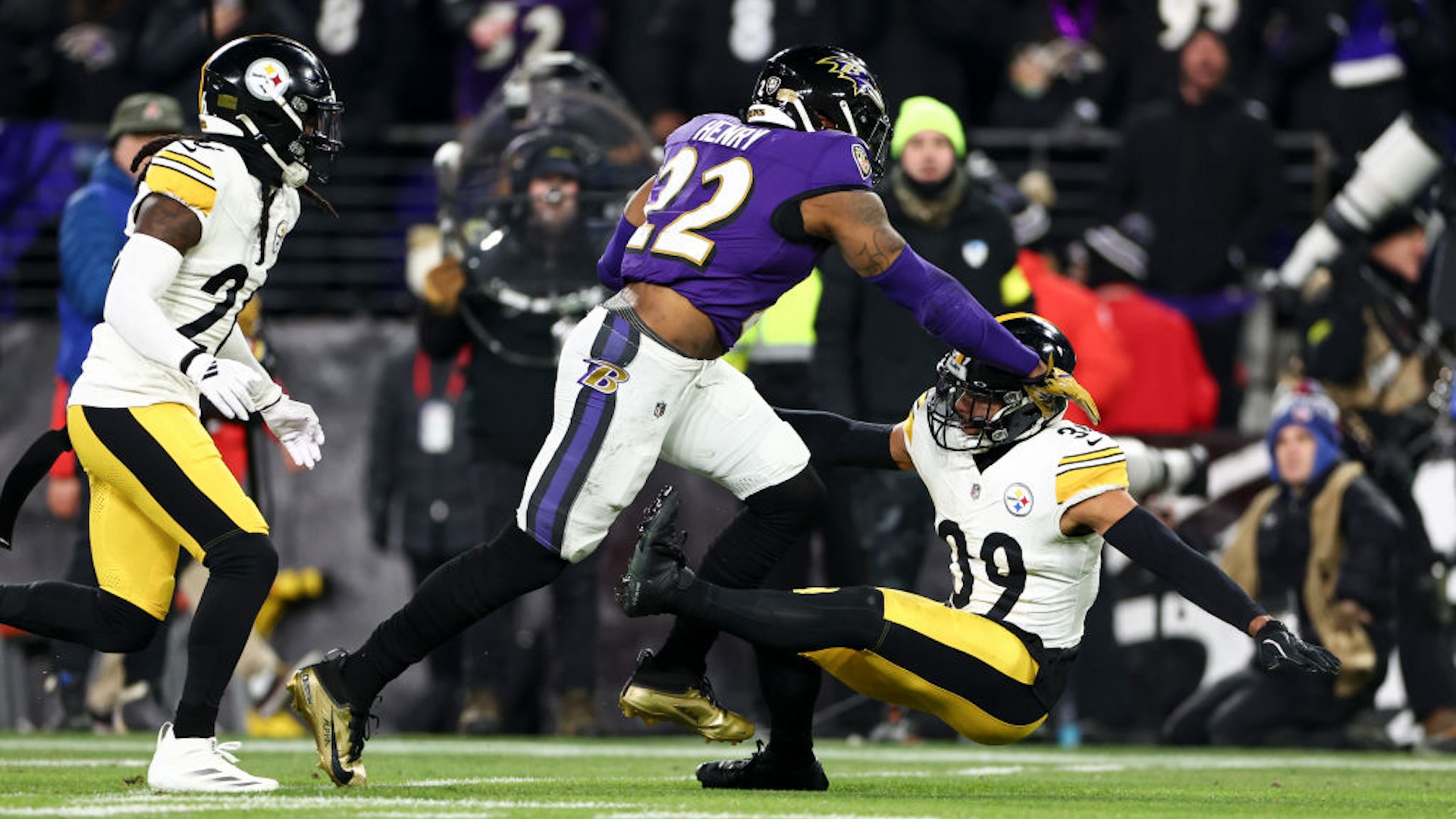 BALTIMORE, MARYLAND - JANUARY 11: Derrick Henry #22 of the Baltimore Ravens stiff arms Minkah Fitzpatrick #39 of the Pittsburgh Steelers during the first half of an NFL football wild card playoff game at M&amp;T Bank Stadium on January 11, 2025 in Baltimore, Maryland.