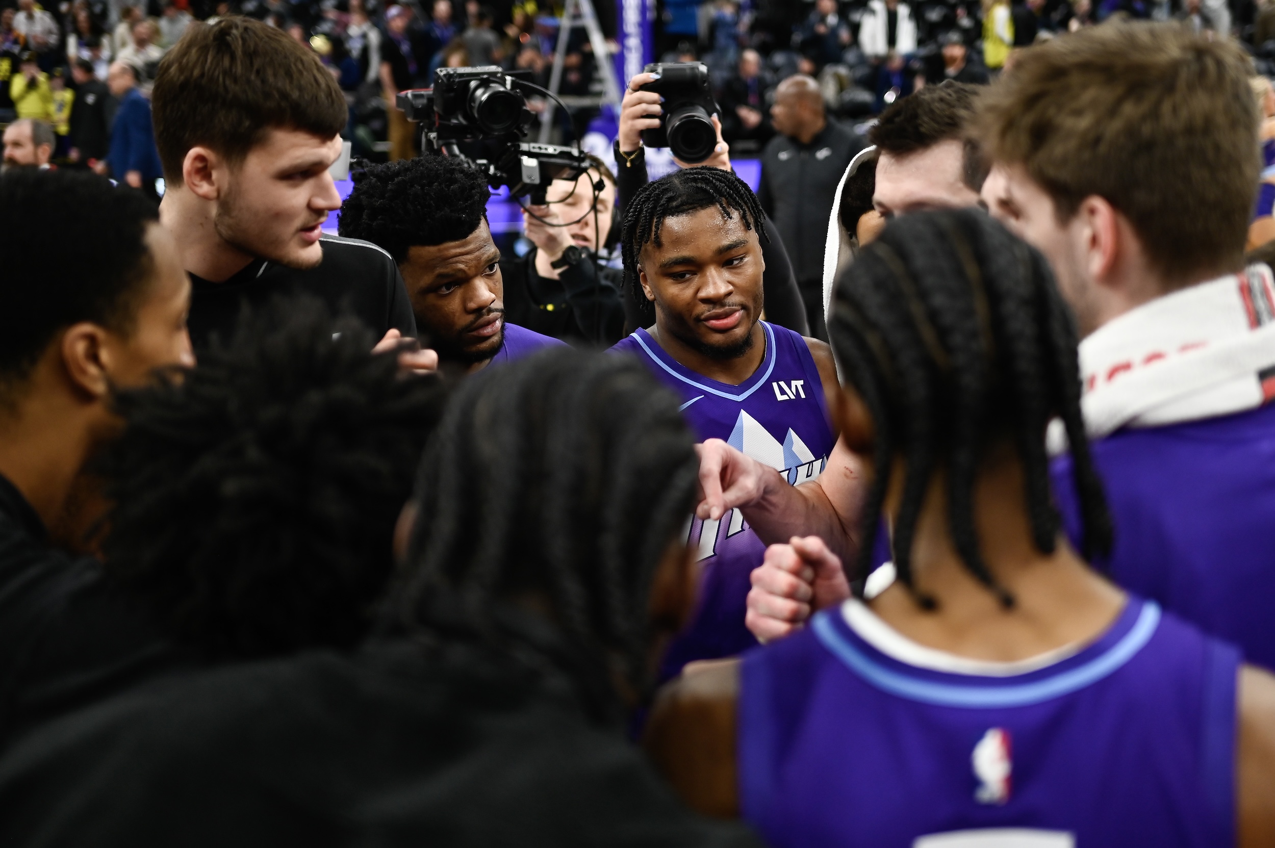 Isaiah Collier huddles with fellow Jazz players.