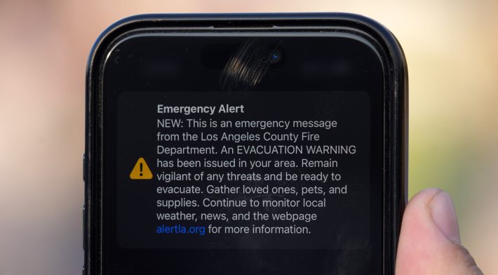 An Emergency Alert evacuation warning on the Apple iPhone15 of Dylan Stewart of Riverside, Calif. during an Eaton Fire press conference on January 09, 2025 at Rose Bowl Stadium in Pasadena, Calif.