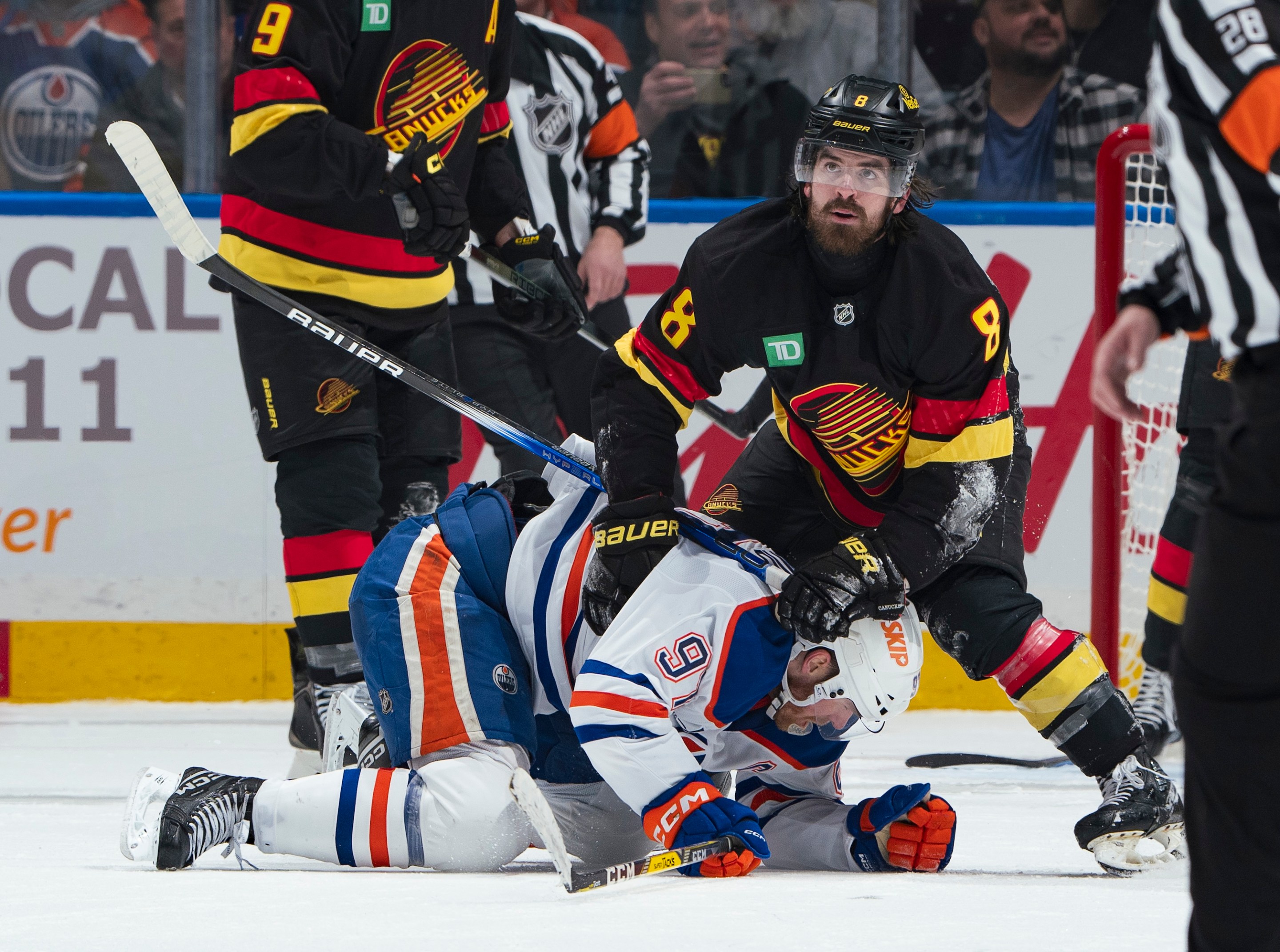 VANCOUVER, CANADA - JANUARY 18: Conor Garland #8 of the Vancouver Canucks checks Connor McDavid #97 of the Edmonton Oilers during the third period of their NHL game at Rogers Arena on January 18, 2025 in Vancouver, British Columbia, Canada. Vancouver won 3-2. (Photo by Jeff Vinnick/NHLI via Getty Images)