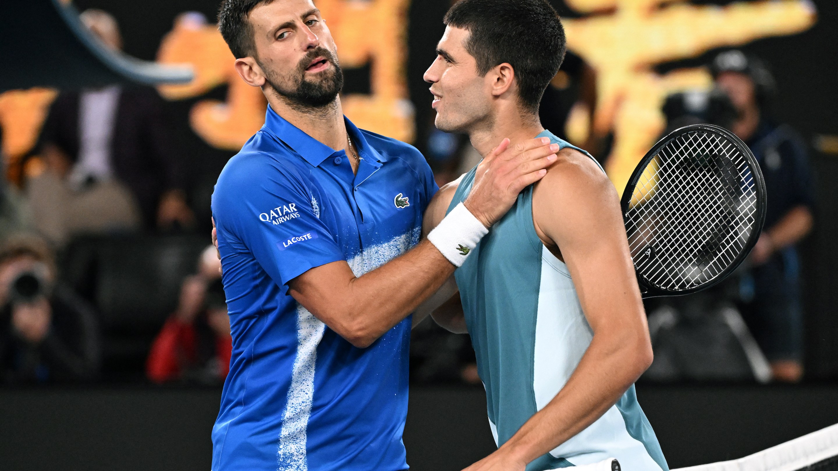 Novak Djokovic and Carlos Alcaraz meet at the net after their Australian Open match.