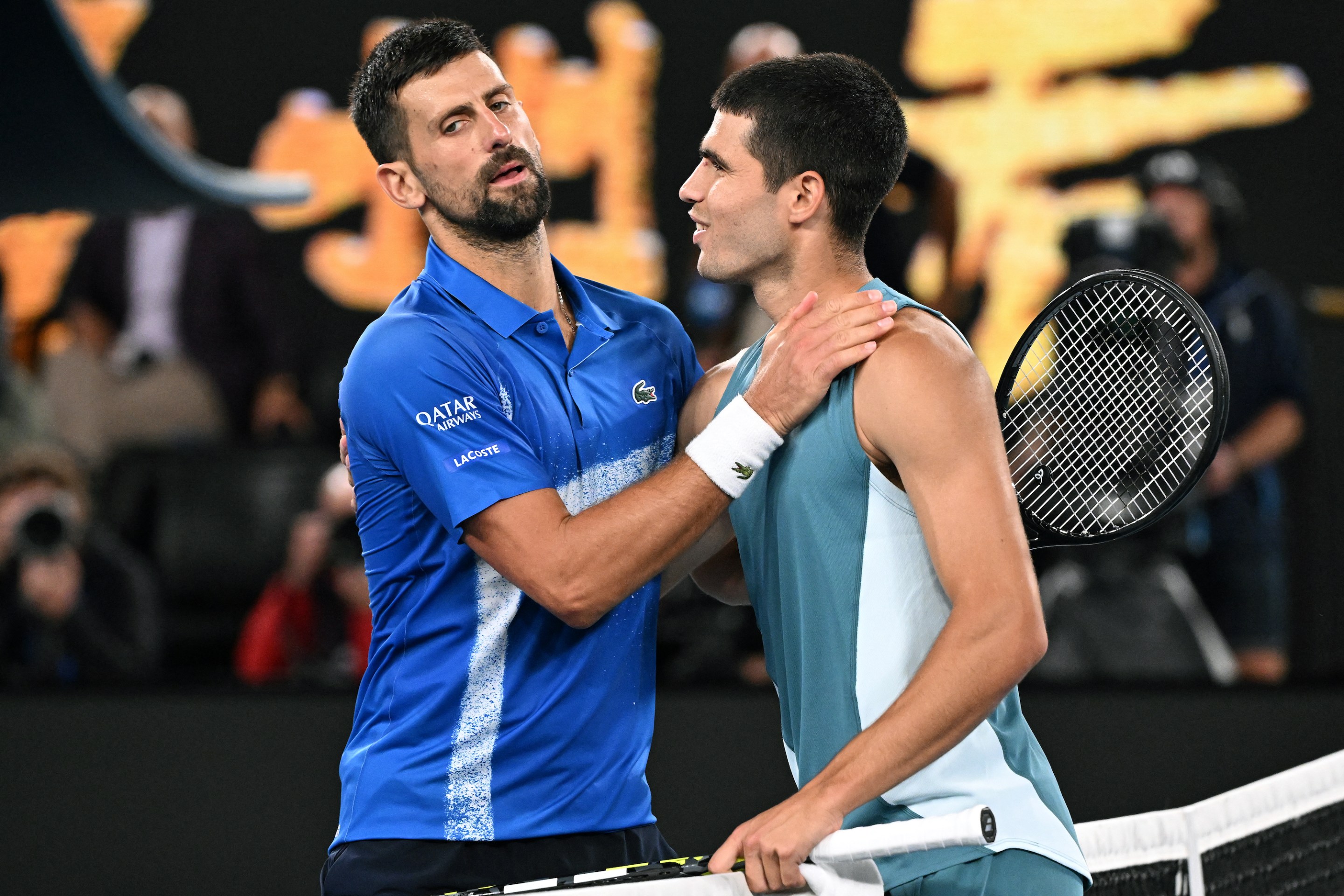 Novak Djokovic and Carlos Alcaraz meet at the net after their Australian Open match.