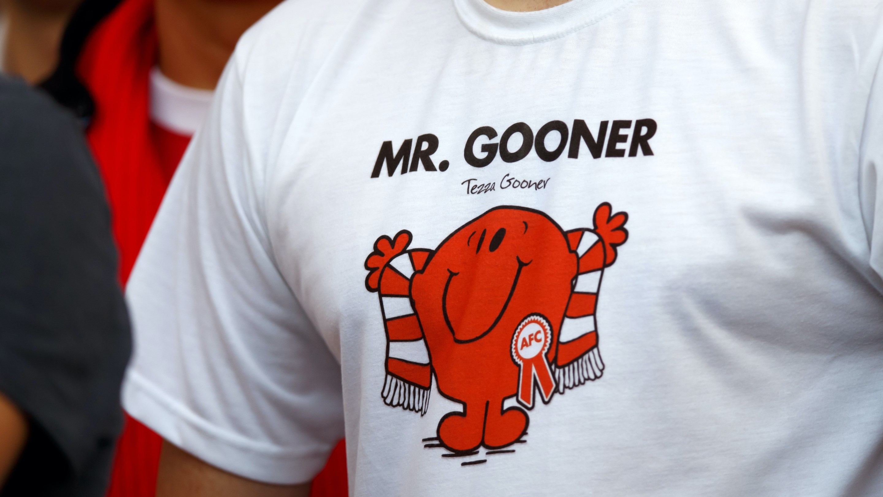 An Arsenal fan wearing a shirt that reads "Mr. Gooner"