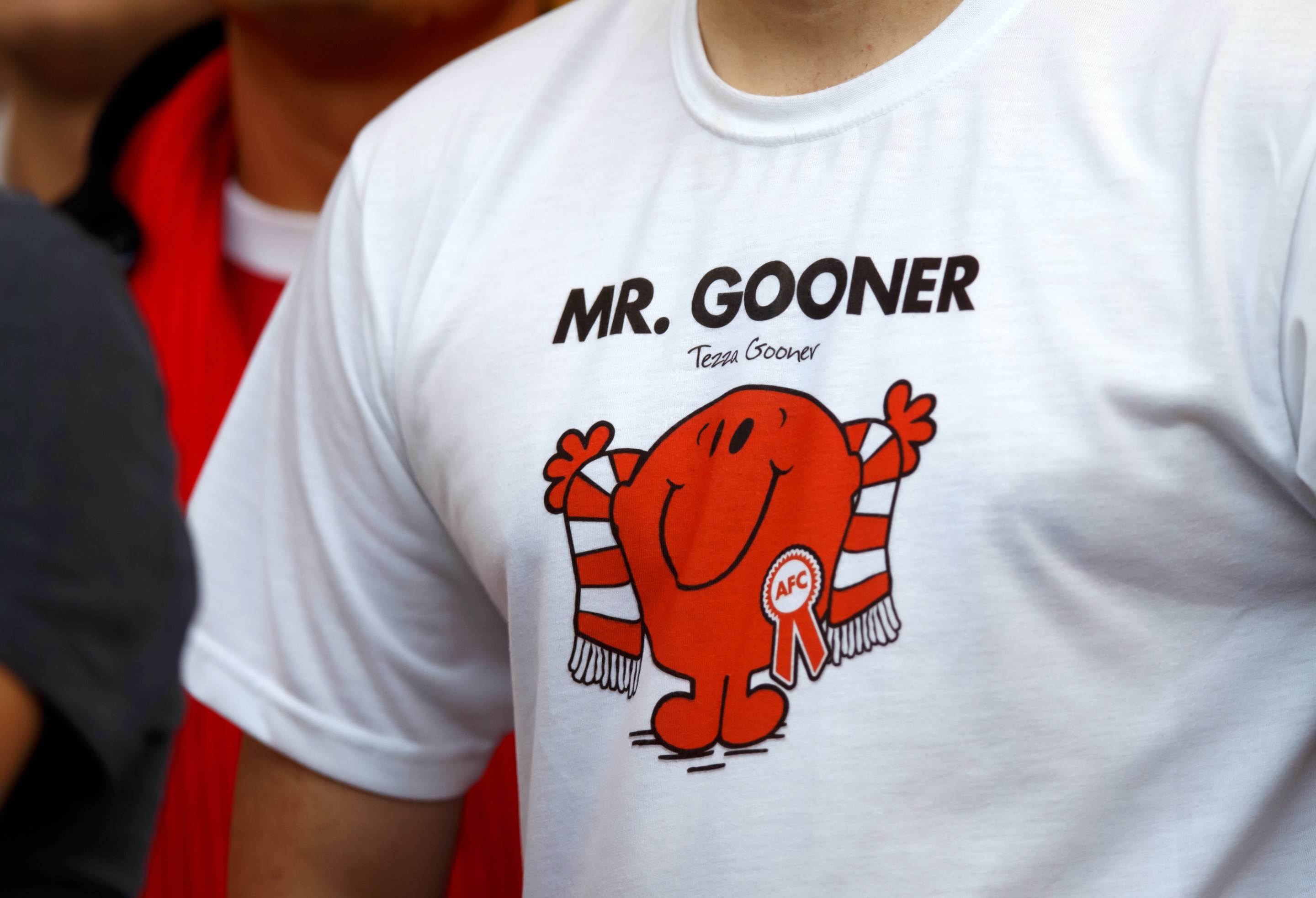 An Arsenal fan wearing a shirt that reads "Mr. Gooner"