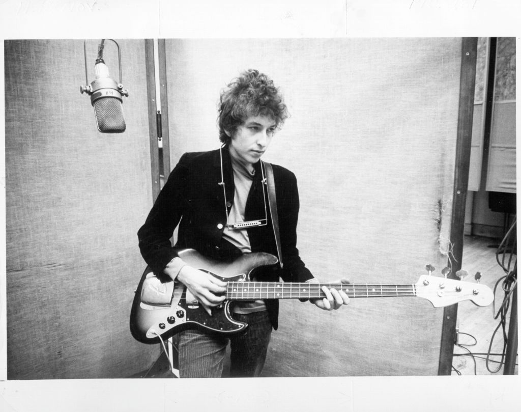 Bob Dylan plays a Fender Jazz bass with the harmonica around his neck while recording his album 'Bringing It All Back Home' on January 13-15, 1965 in Columbia's Studio A in New York City,