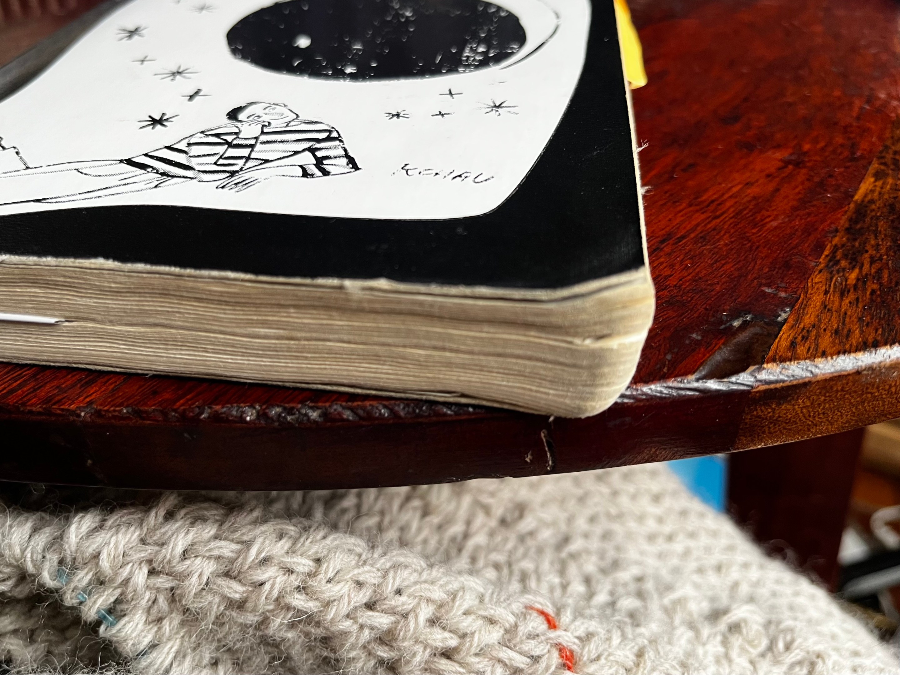 An image of one of Alex's old journals, sitting on a very nice wood table.