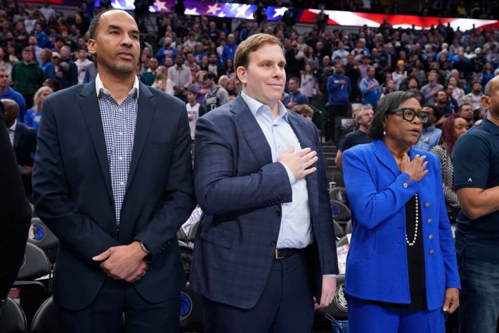 General manager Nico Harrison, new majority owner and Governor Patrick Dumont and CEO Cynt Marshall of the Dallas Mavericks stand during the playing of the U.S. national anthem before the game against the Washington Wizards at American Airlines Center on February 12, 2024 in Dallas, Texas.