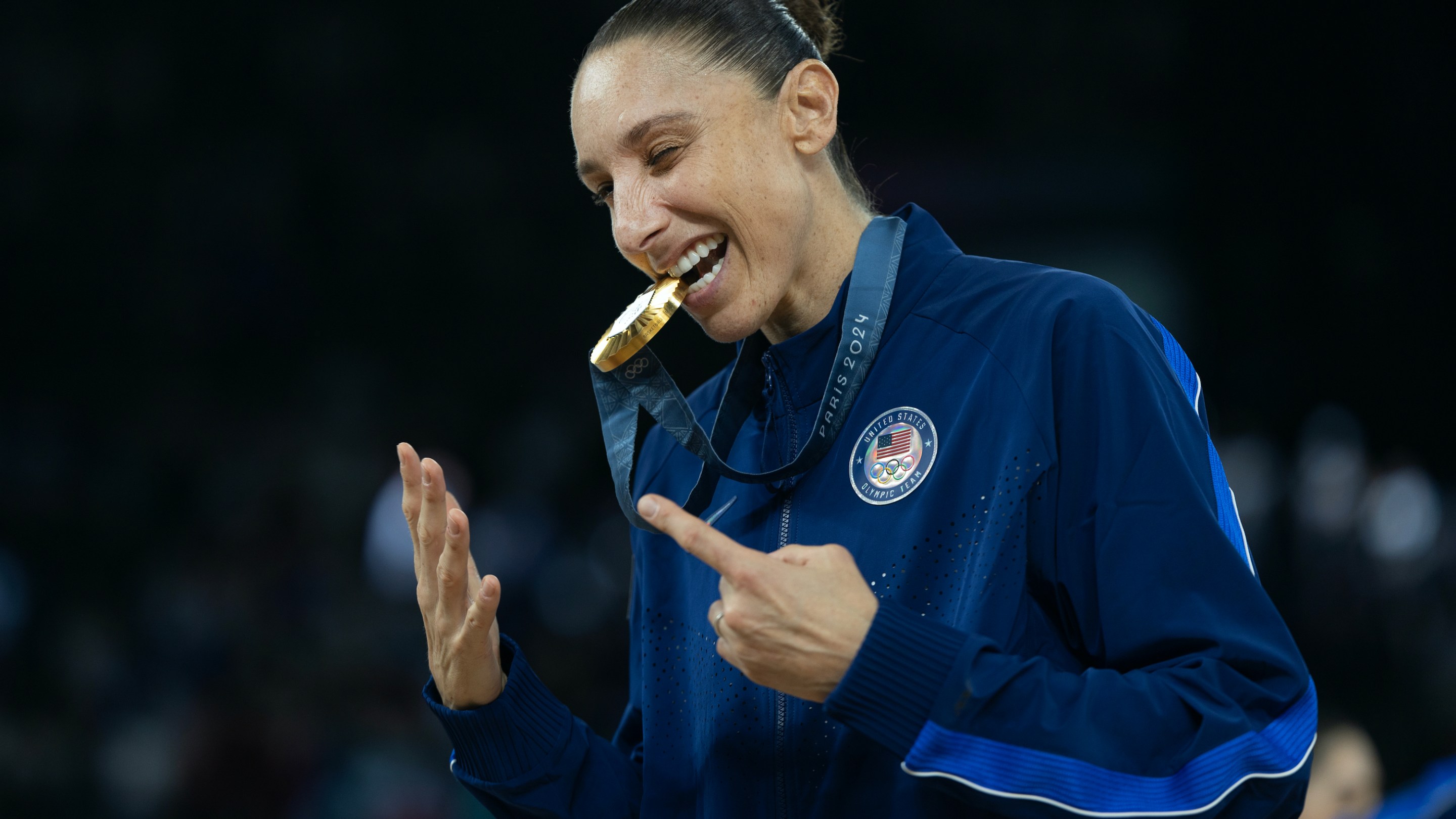 Diana Taurasi bites her sixth Olympic gold.