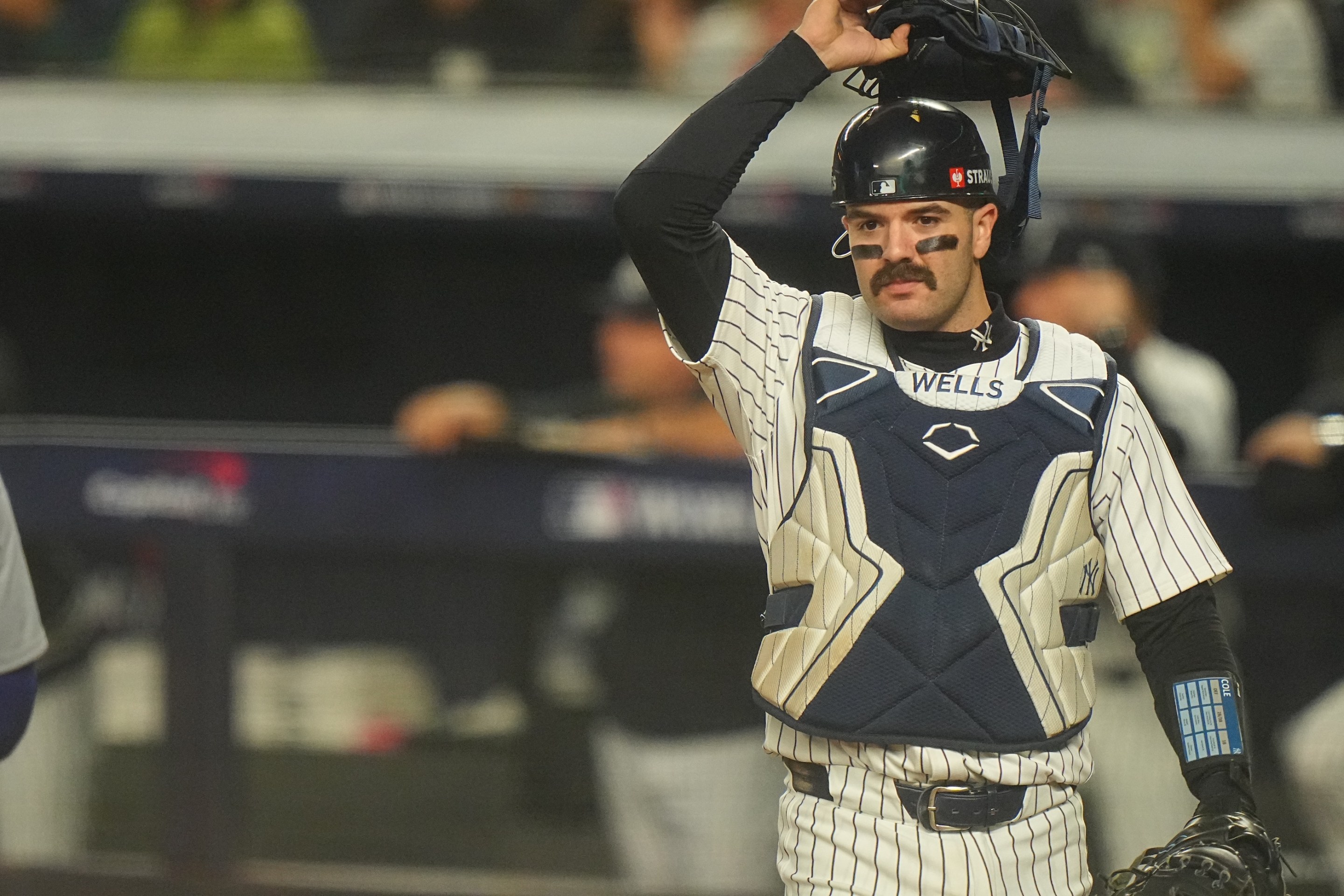 Austin Wells in action, looks on from behind the plate vs Los Angeles Dodgers at Yankee Stadium. Game 5. Big ol mustache on his upper lip.