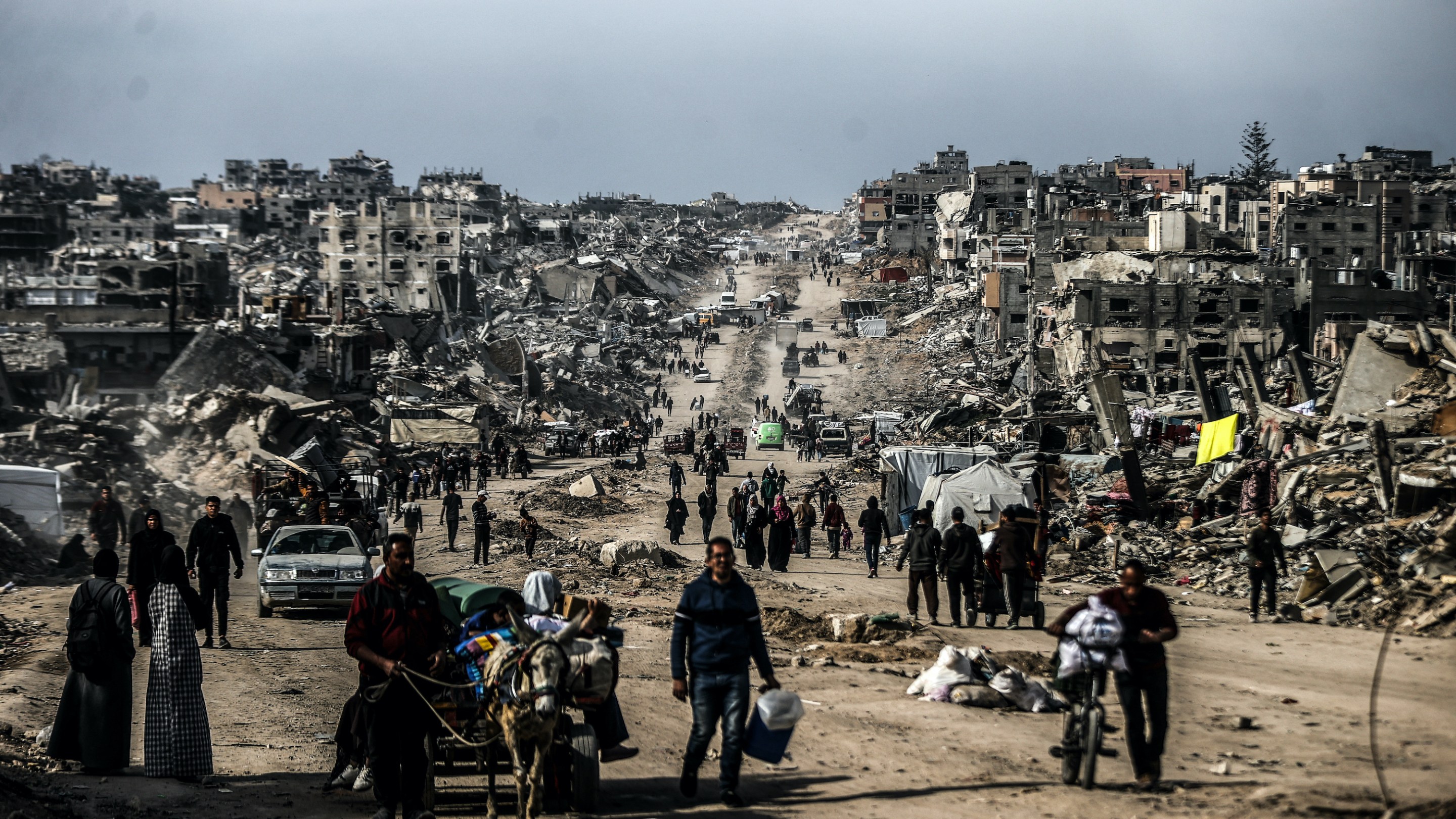 Palestinians walk through the destruction in Gaza.