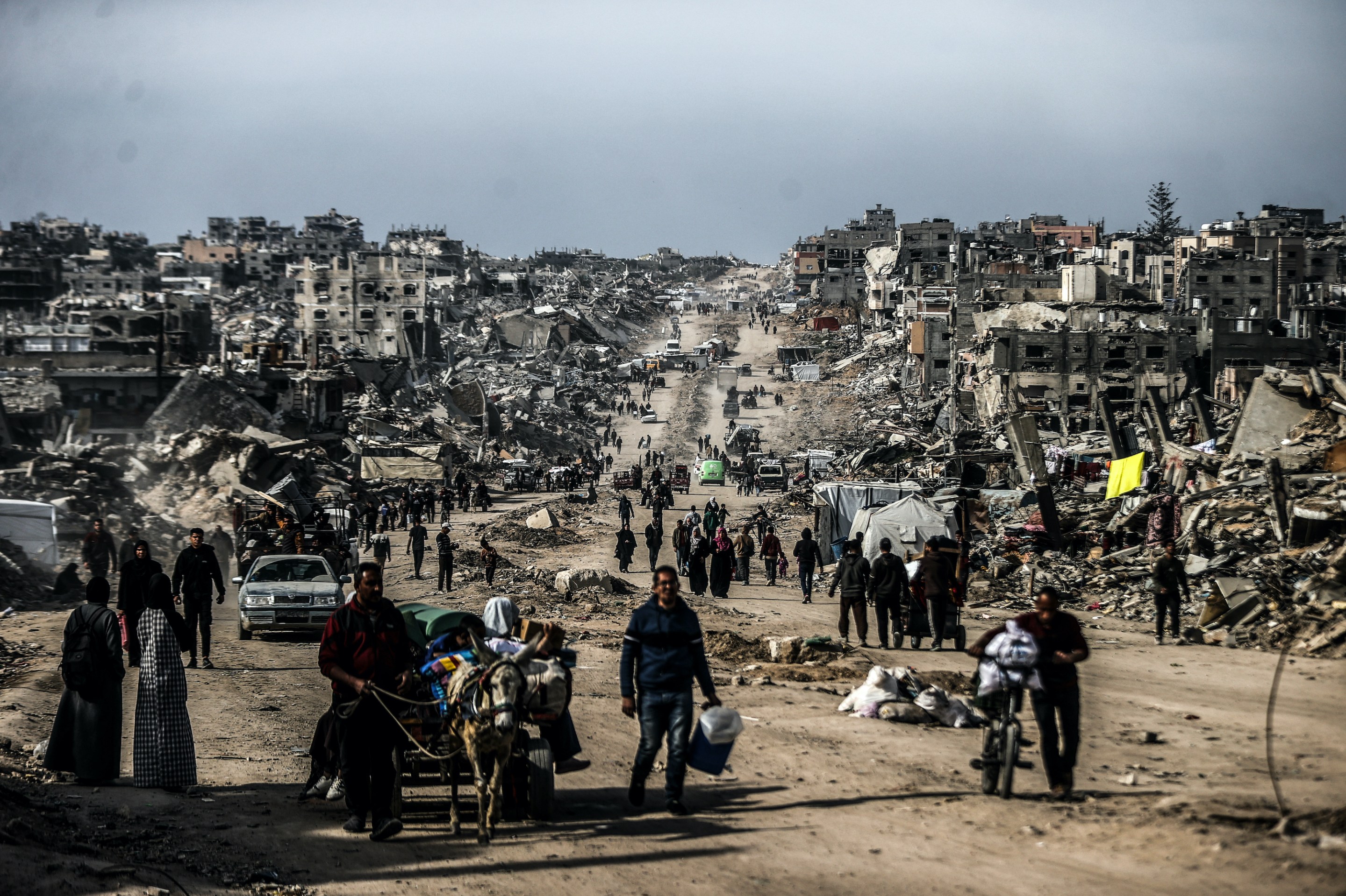 Palestinians walk through the destruction in Gaza.