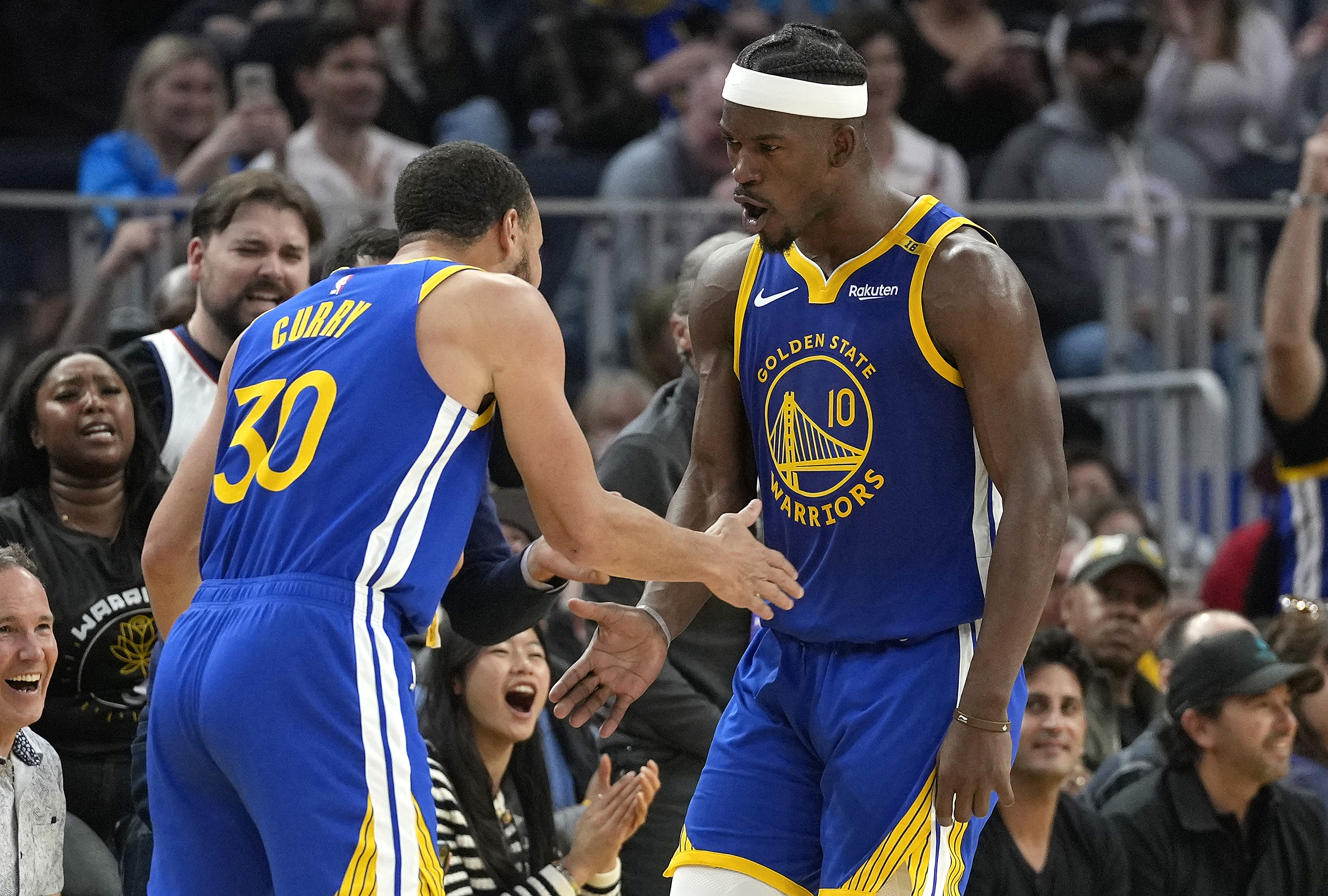 and Stephen Curry #30 of the Golden State Warriors celebrate after Butler scored and was fouled on the shot against the Dallas Mavericks on February 23, 2025.