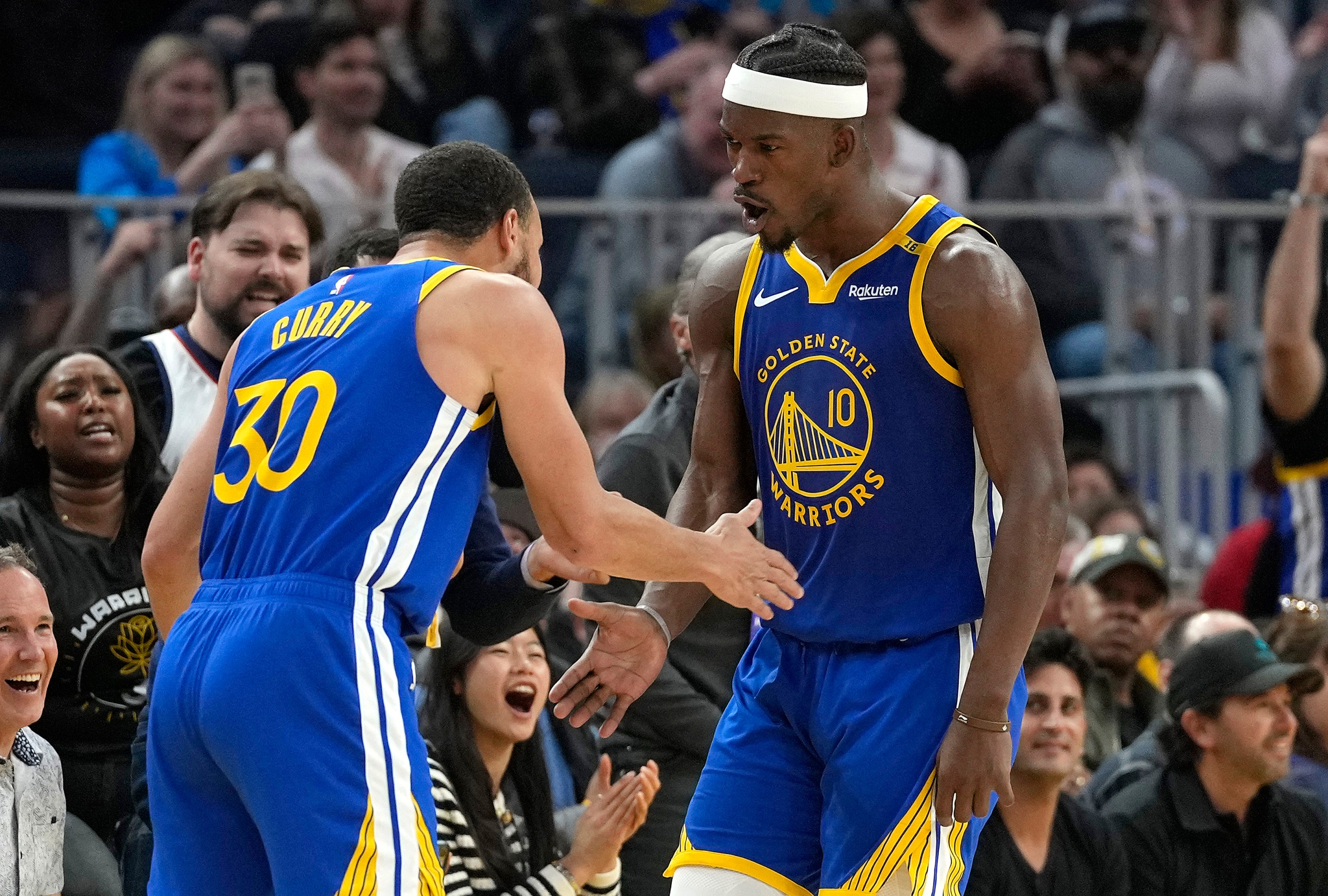 and Stephen Curry #30 of the Golden State Warriors celebrate after Butler scored and was fouled on the shot against the Dallas Mavericks on February 23, 2025.