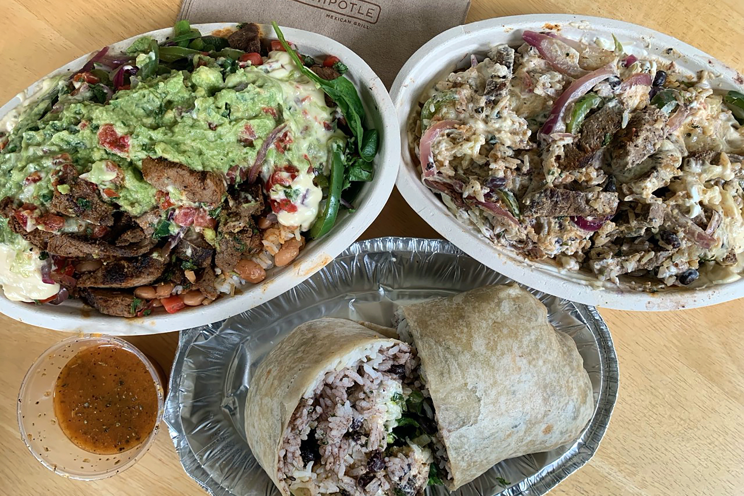 Three big sloppy bowls of Chipotle.