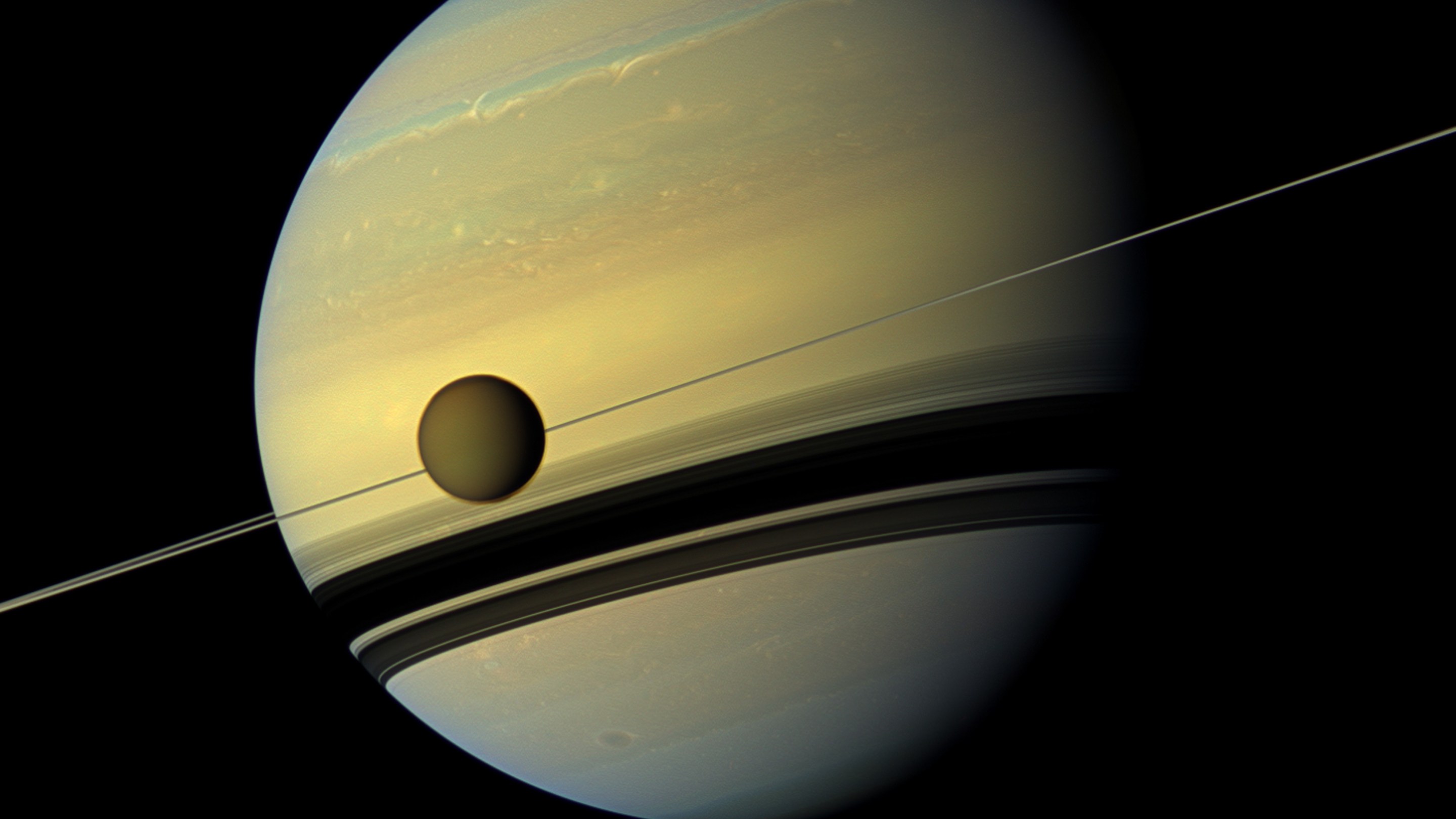 A giant of a moon appears before a giant of a planet undergoing seasonal changes in this natural color view of Titan and Saturn from NASA's Cassini spacecraft. (Photo by: Universal History Archive/Universal Images Group via Getty Images)