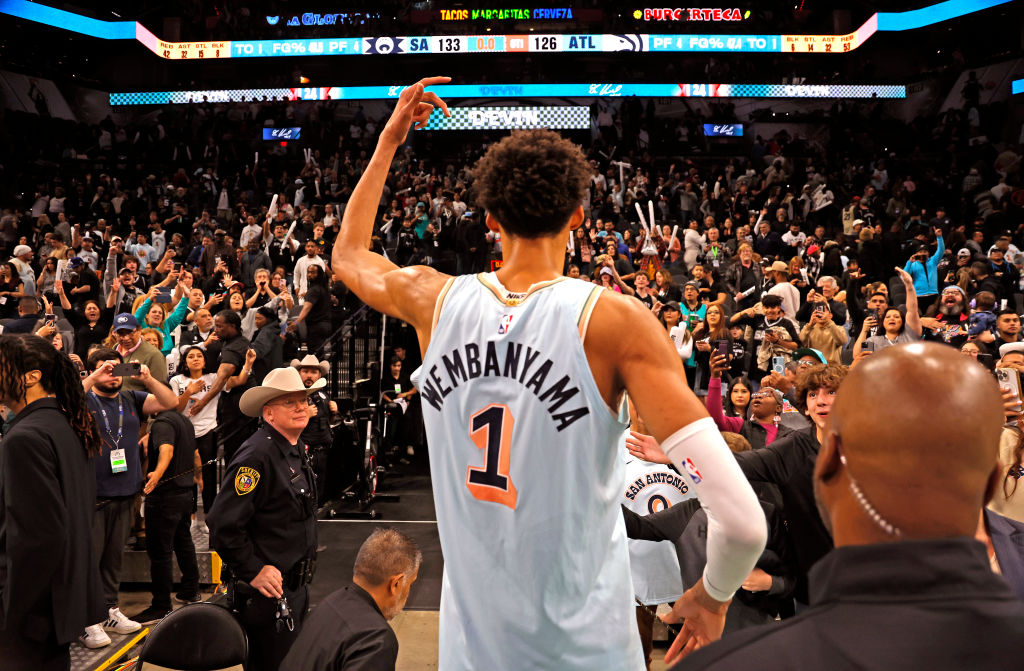 San Antonio Spurs star Victor Wembanyama walks off the court and waves to fans after a game.