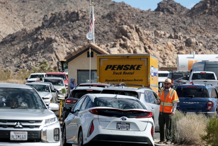 A National Park Service park ranger helps direct traffic at an entrance to Joshua Tree National Park, to prevent traffic from backing up into the adjacent community, on February 19, 2025 in Joshua Tree, California