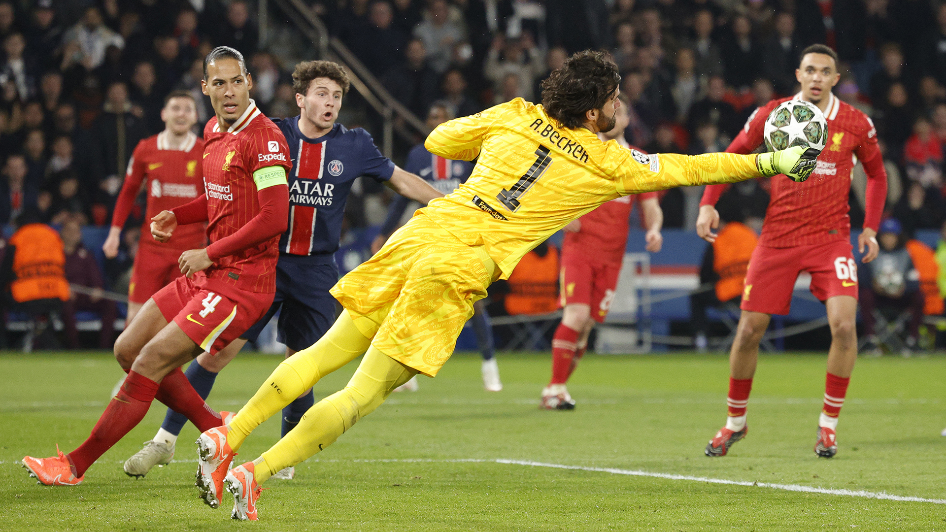 Liverpool's Brazilian goalkeeper #01 Alisson (C) dives to punch the ball during the UEFA Champions League Round of 16 first leg football match between Paris Saint-Germain (FRA) and Liverpool (ENG) at the Parc des Princes stadium in Paris on March 5, 2025.